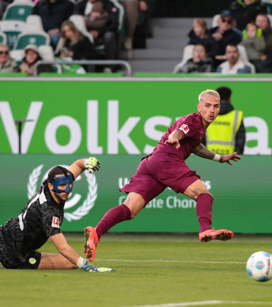 Torschütze Phillip Tietz (FC Augsburg,21) trifft zum 0-1 gegen Torwart Kamil Grabara (VfL Wolfsburg,1).