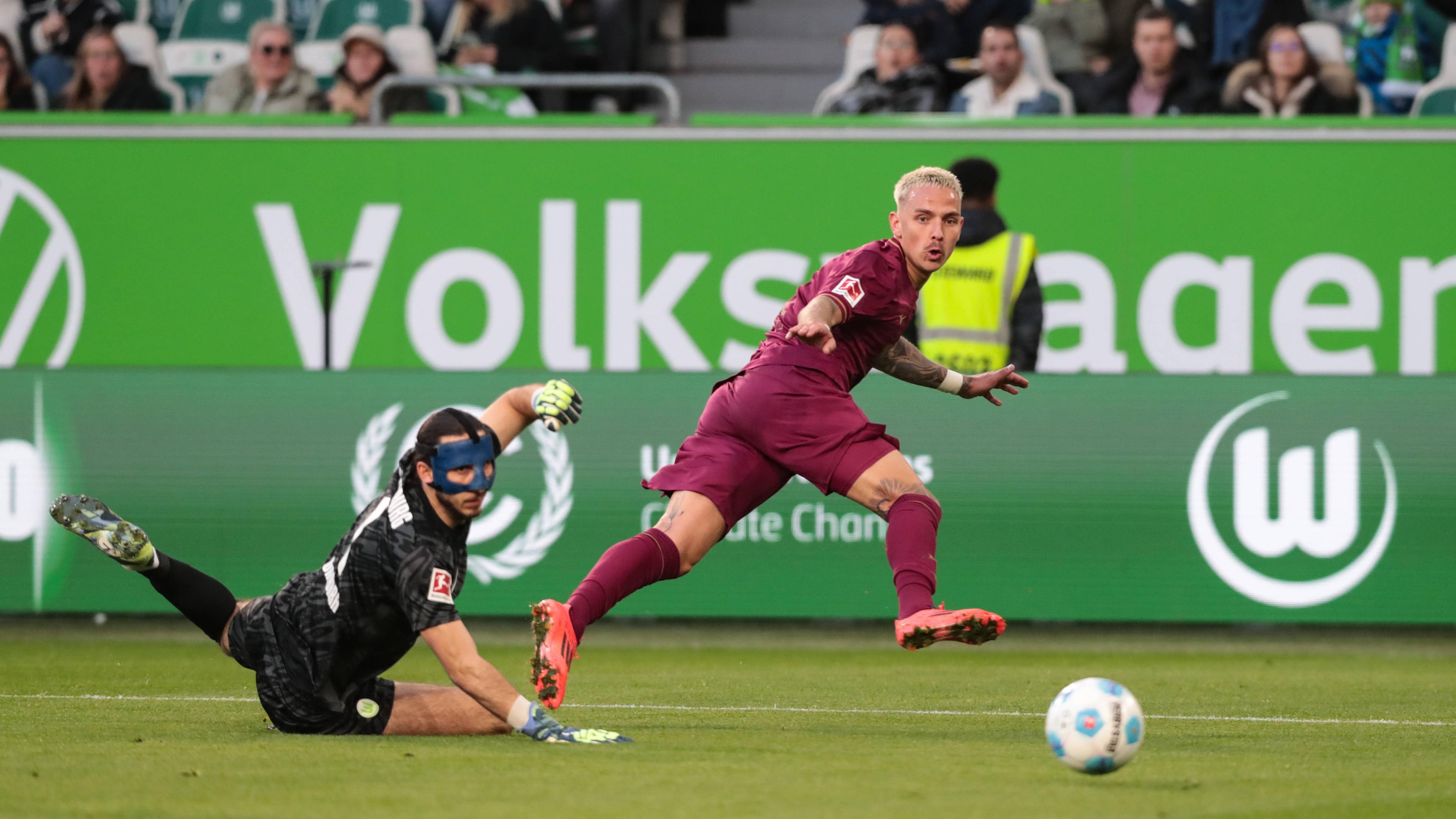 Torschütze Phillip Tietz (FC Augsburg,21) trifft zum 0-1 gegen Torwart Kamil Grabara (VfL Wolfsburg,1).