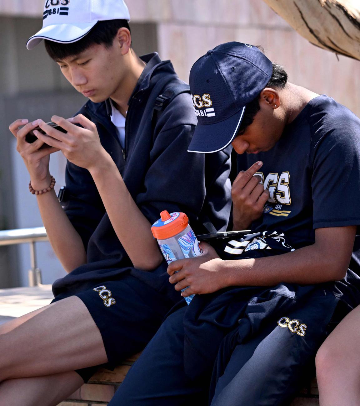 Australien, Melbourne: Schüler schauen auf ihre Smartphones