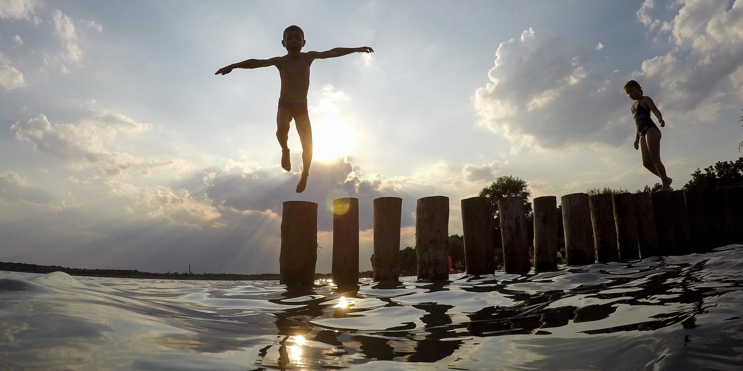 Ein Junge springt von einer Buhne in den Markkleeberger See