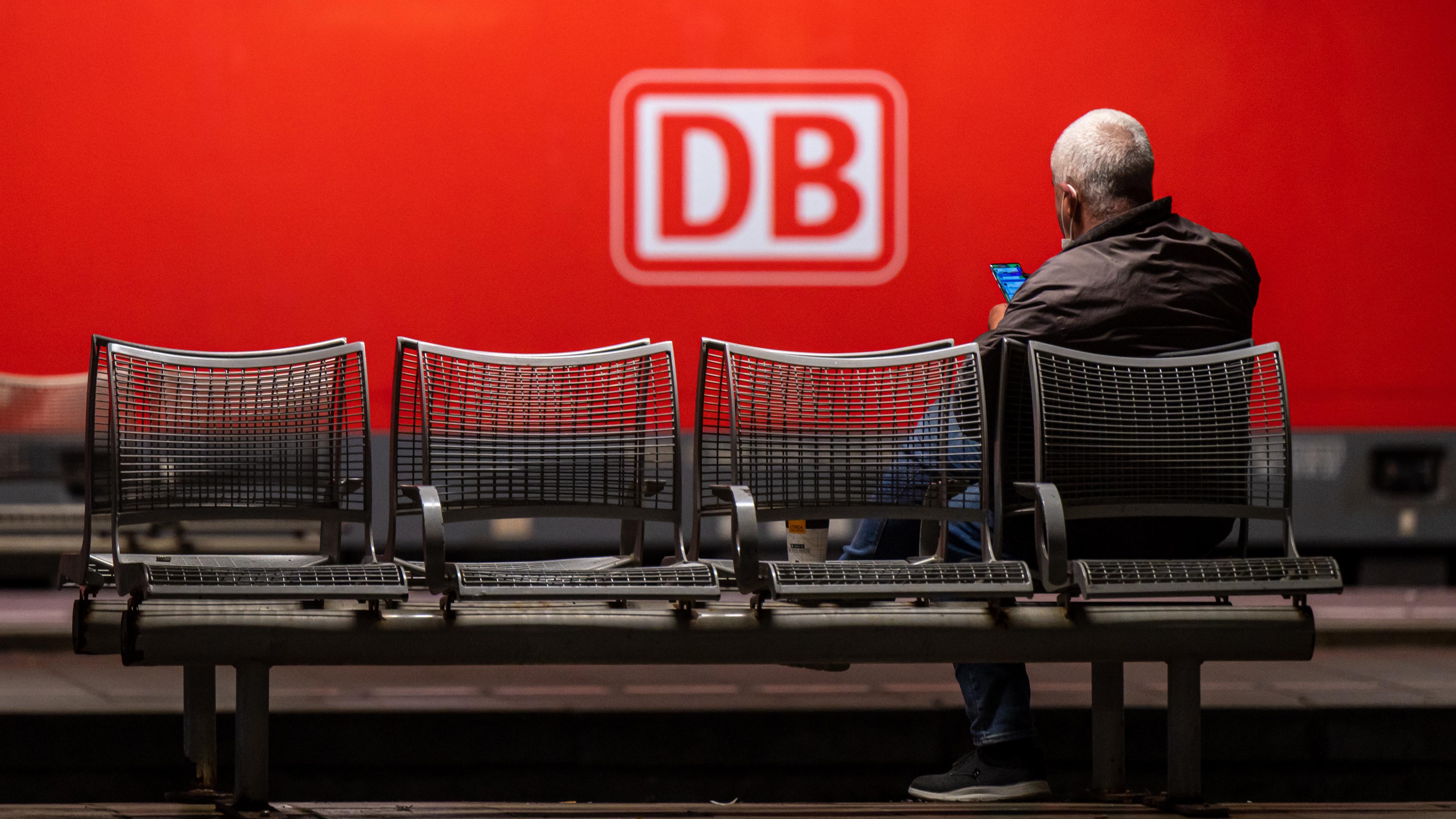 Ein Mann am Münchner Hauptbahnhof wartet auf einer Sitzbank.