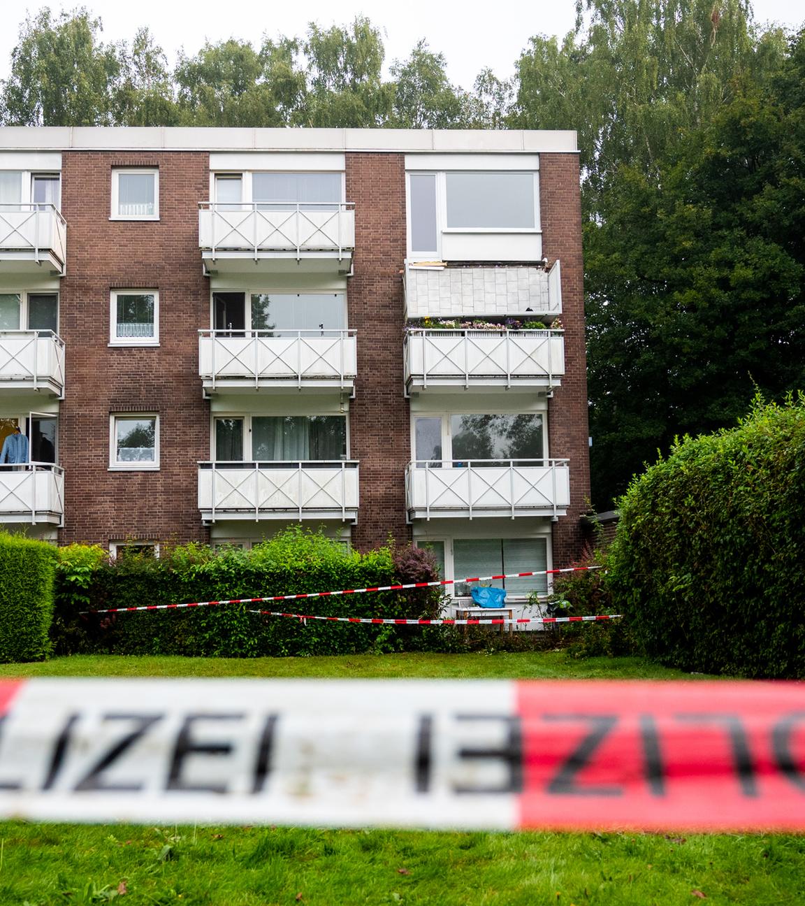 Absperrband der Polizei hängt im Stadtteil Langenhorn vor einem Mehrfamilienhaus. 