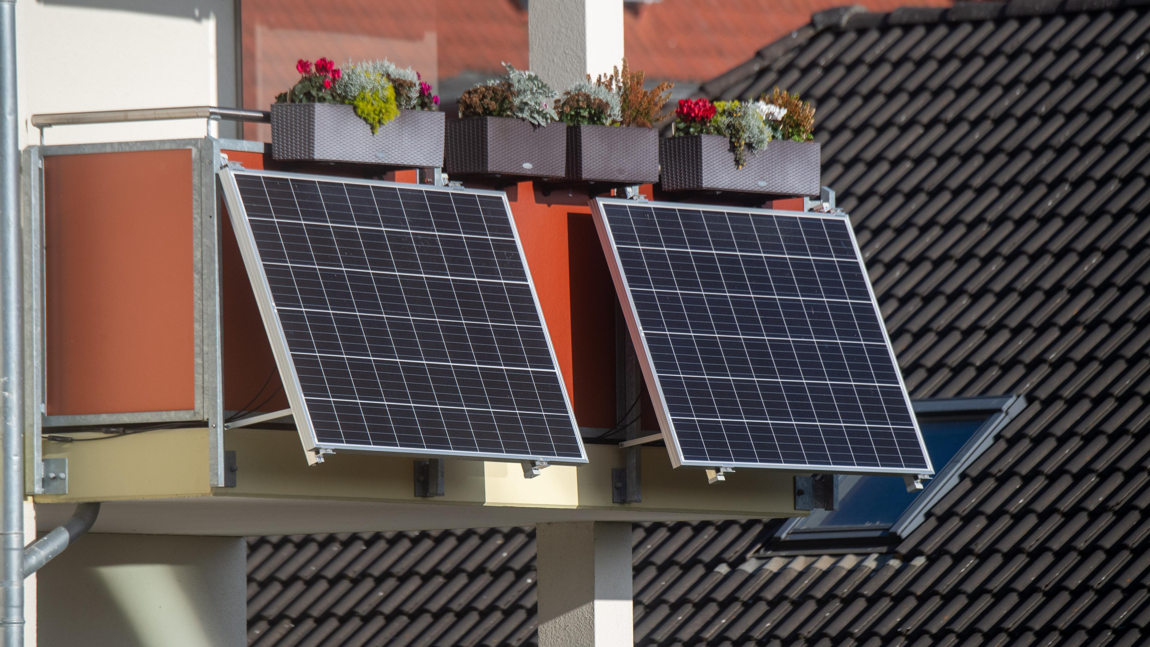 Solarmodule für ein Balkonkraftwerk hängen an einem Balkon.