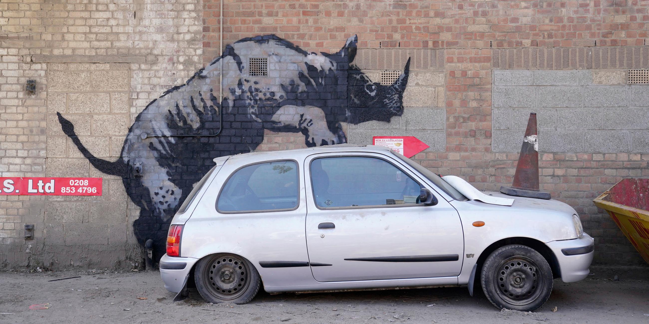 Ein neues Banksy-Kunstwerk. Ein Nashorn, dass auf ein Auto "klettert"