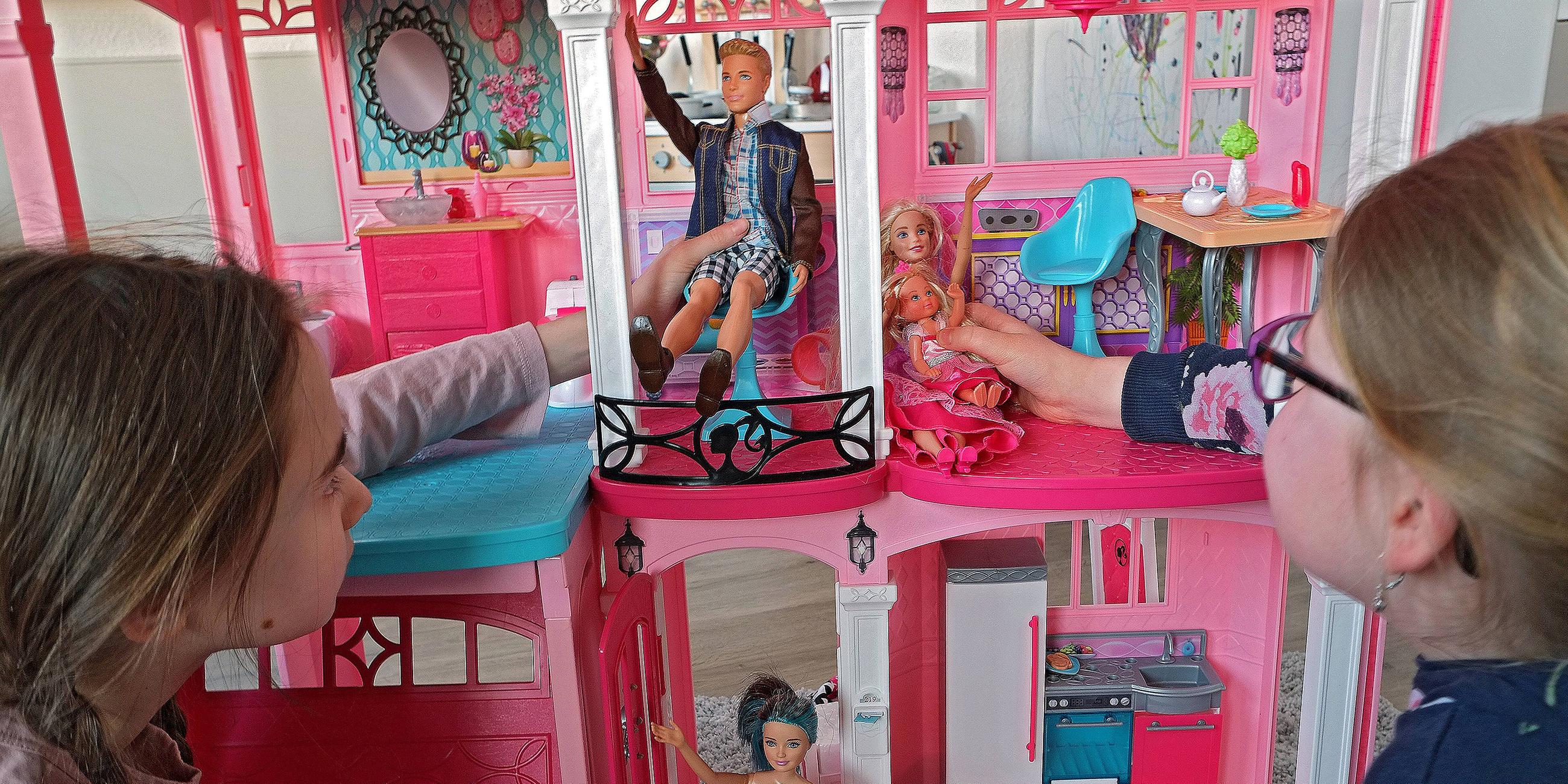 Kinder spielen mit dem Barbie-Haus