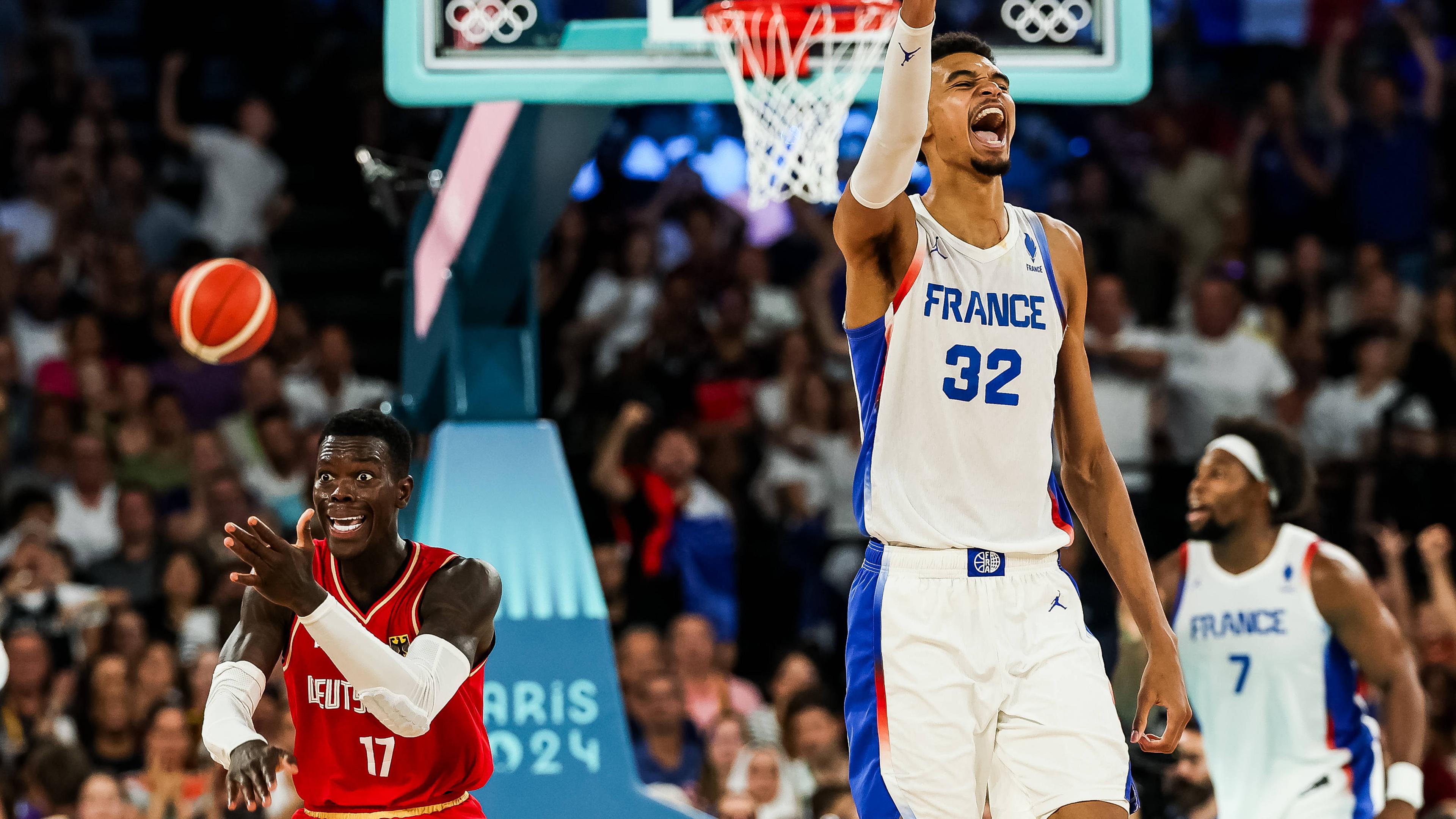 Dennis Schröder (Deutschland) fassungslos über eine Schiedsrichterentscheidung kurz vor Schluss und Victor Wembanyama (Frankreich), der über Frankreichs Sieg jubelt.