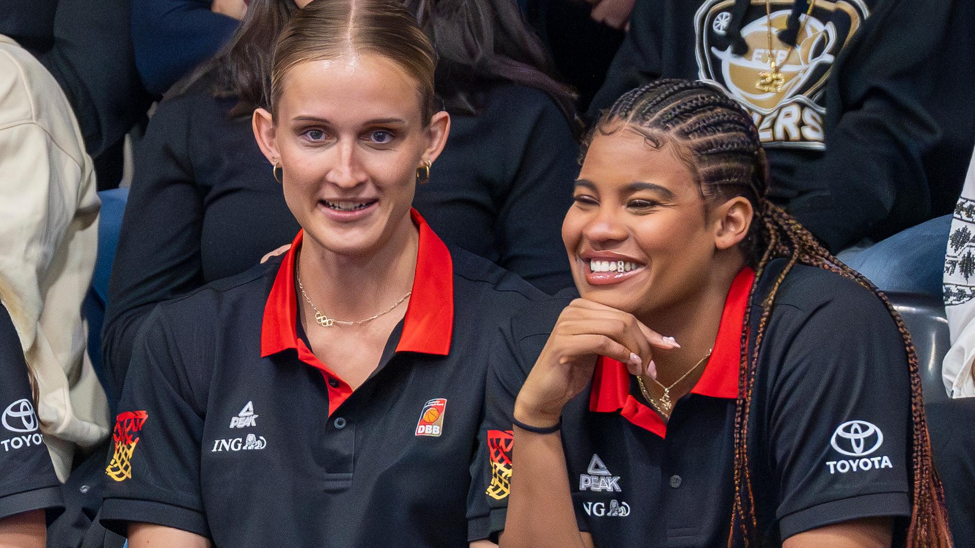 Leonie Fiebich (l) und Nyara Sabally sitzen auf der Tribüne.