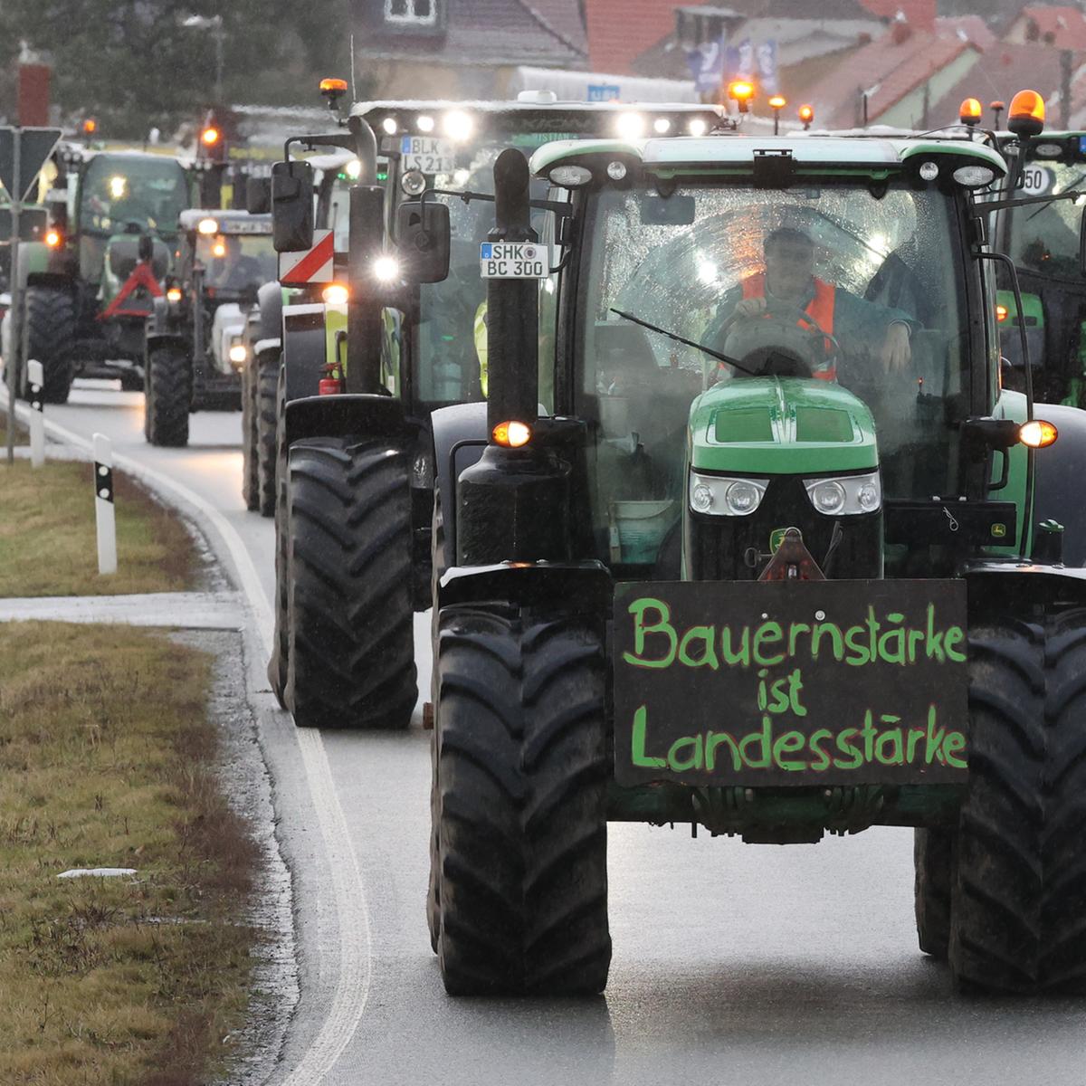 Landwirte fahren mit ihren Traktoren über die Bundesstraße 7.