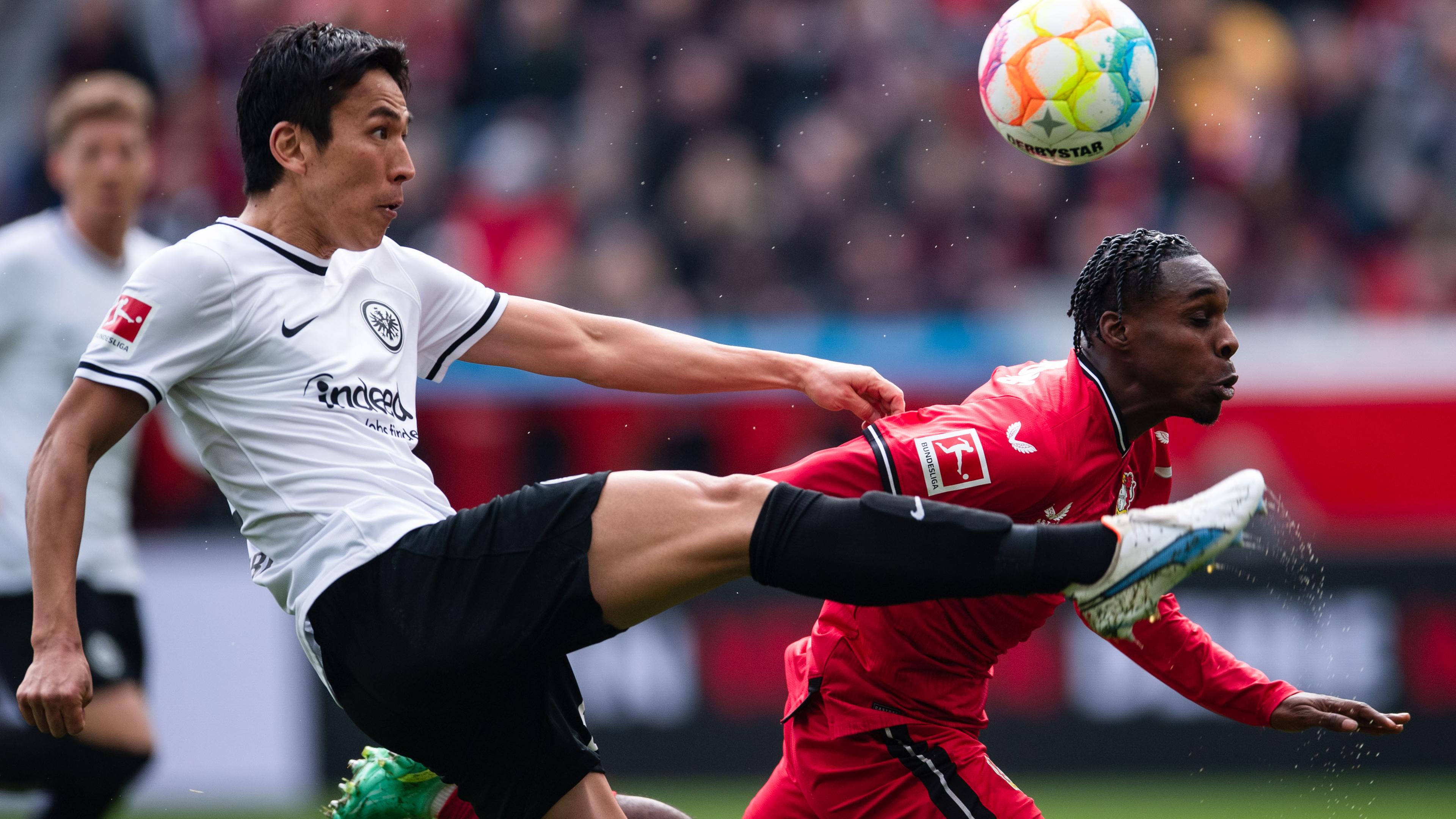 Leverkusens Jeremie Frimpong (r) und Frankfurts Makoto Hasebe kämpfen um den Ball.