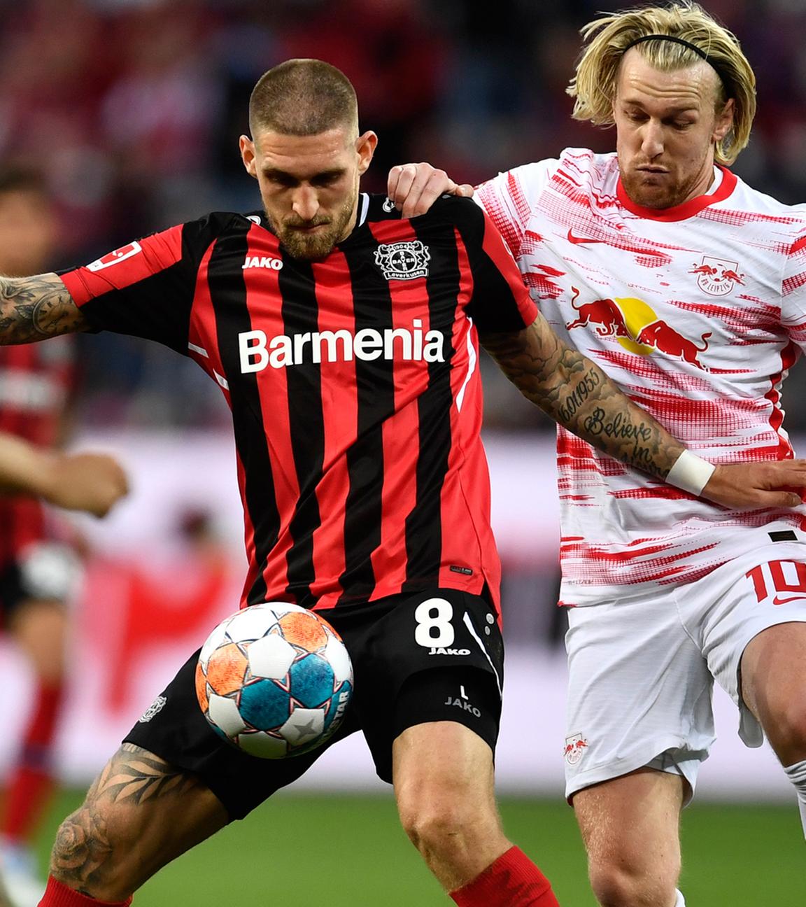 17.04.2022, Nordrhein-Westfalen, Leverkusen: Fußball: Bundesliga, Bayer Leverkusen - RB Leipzig, 30. Spieltag, BayArena: Leverkusens Robert Andrich (M) kämpft mit Leipzigs Tyler Adams (l) und Leipzigs Emil Forsberg (r) um den Ball.