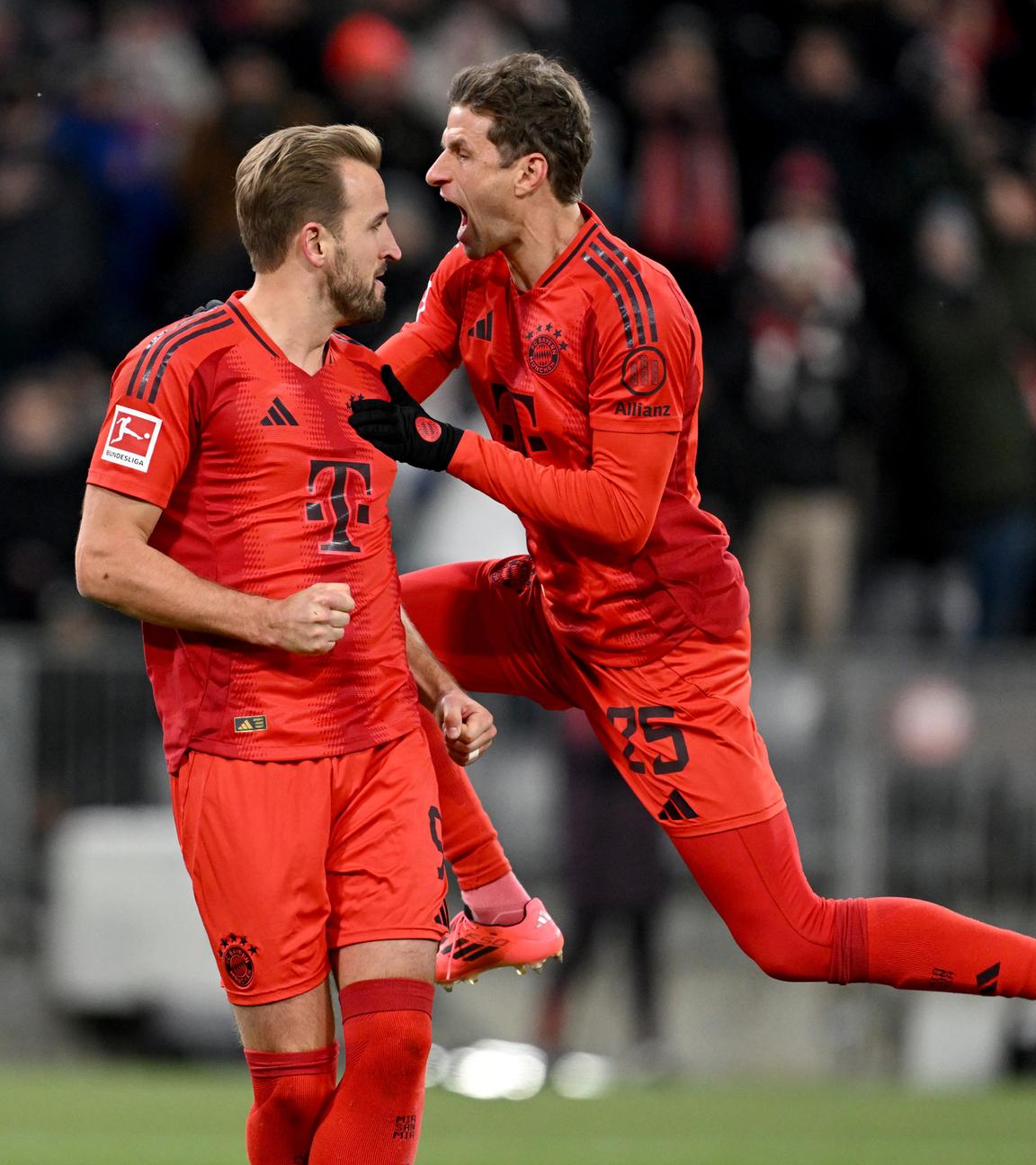 Bayern Münchens Harry Kane (l) bejubelt sein Tor zum 2:0 durch Foulelfmeter mit Bayern Münchens Thomas Müller.