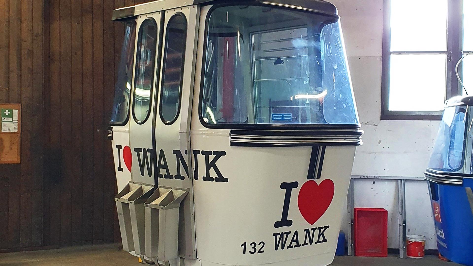 Eine Gondel der Wankbahn mit dem Logo "I love Wank" in einer Seilbahnstation.