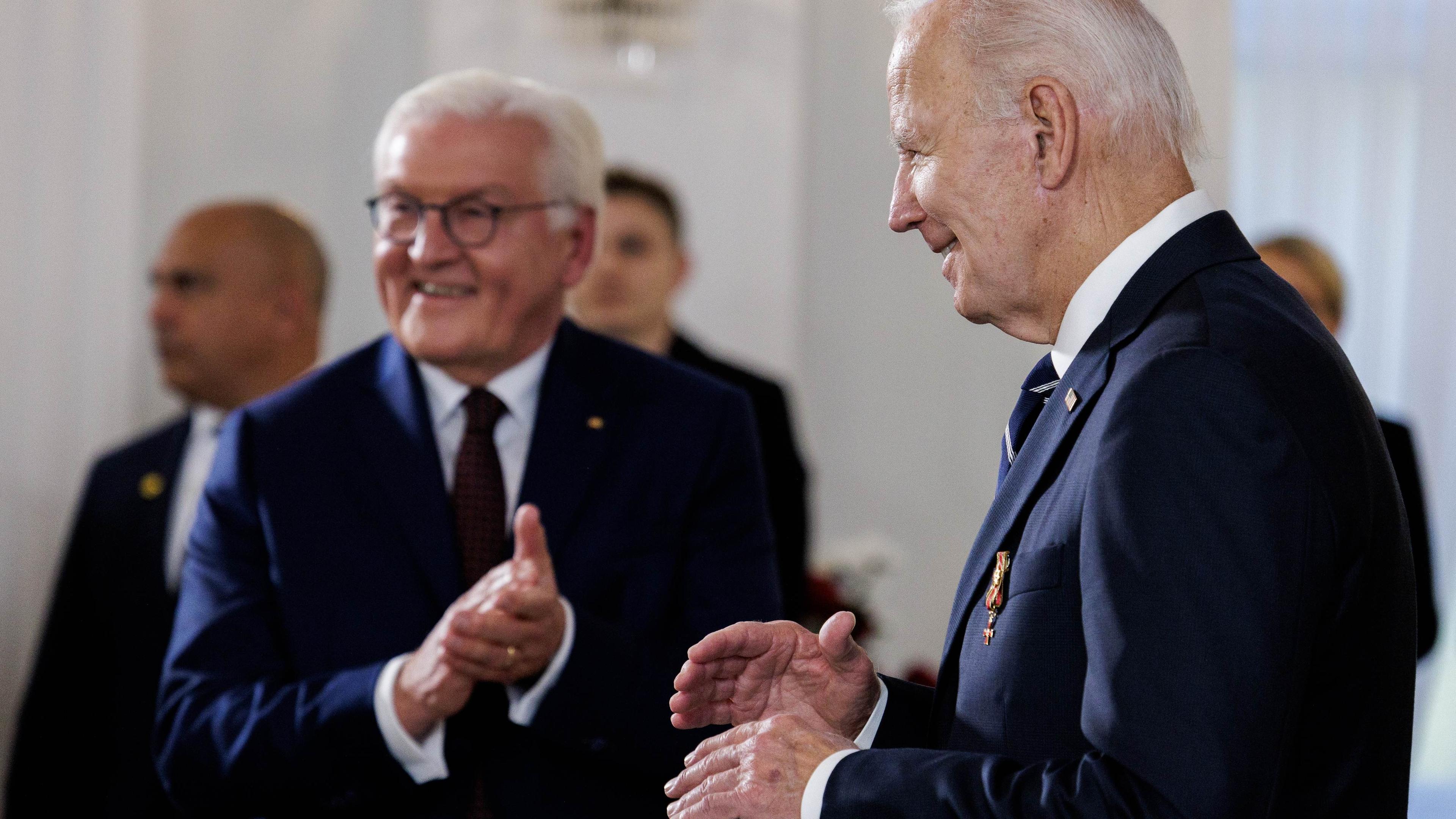 German President Frank-Walter Steinmeier (L) applauds US President Joe Biden after the award ceremnony of the Federal Medal of Merit at Schloss Bellevue