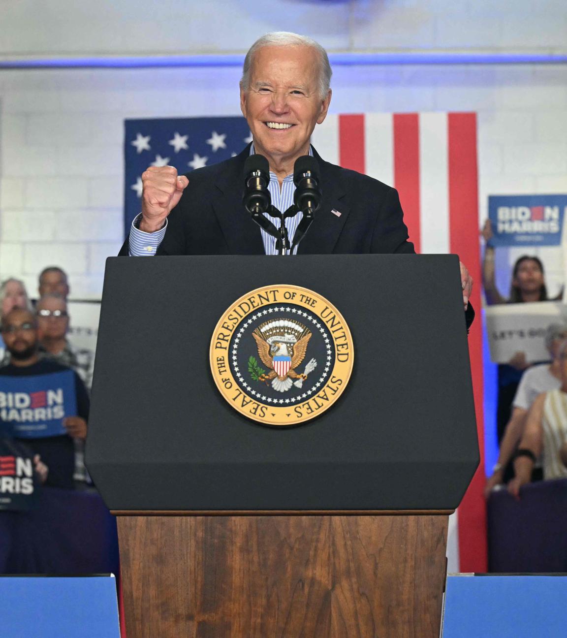 US-Präsident Joe Biden steht bei einer Wahlkampfverantstaltung auf einer Bühne und ballt die Faust und lächelt in die Kamera.