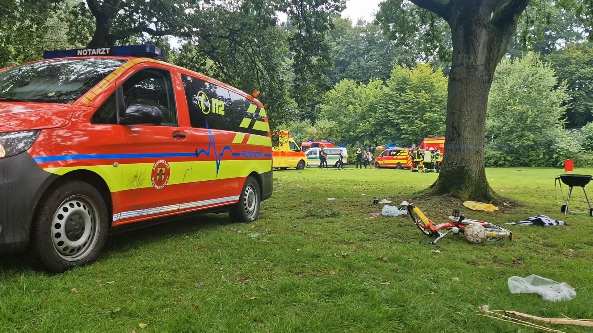 Rettungswagen und Einsatzkräfte in einem Park in Delmenhorst. Ein Biltzeinschlag traf eine achtköpfige Familie