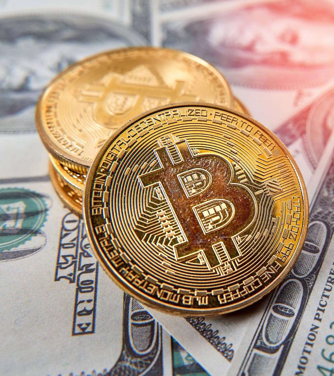 Bitcoin-Goldmünzen auf US-Dollar-Geldscheinen