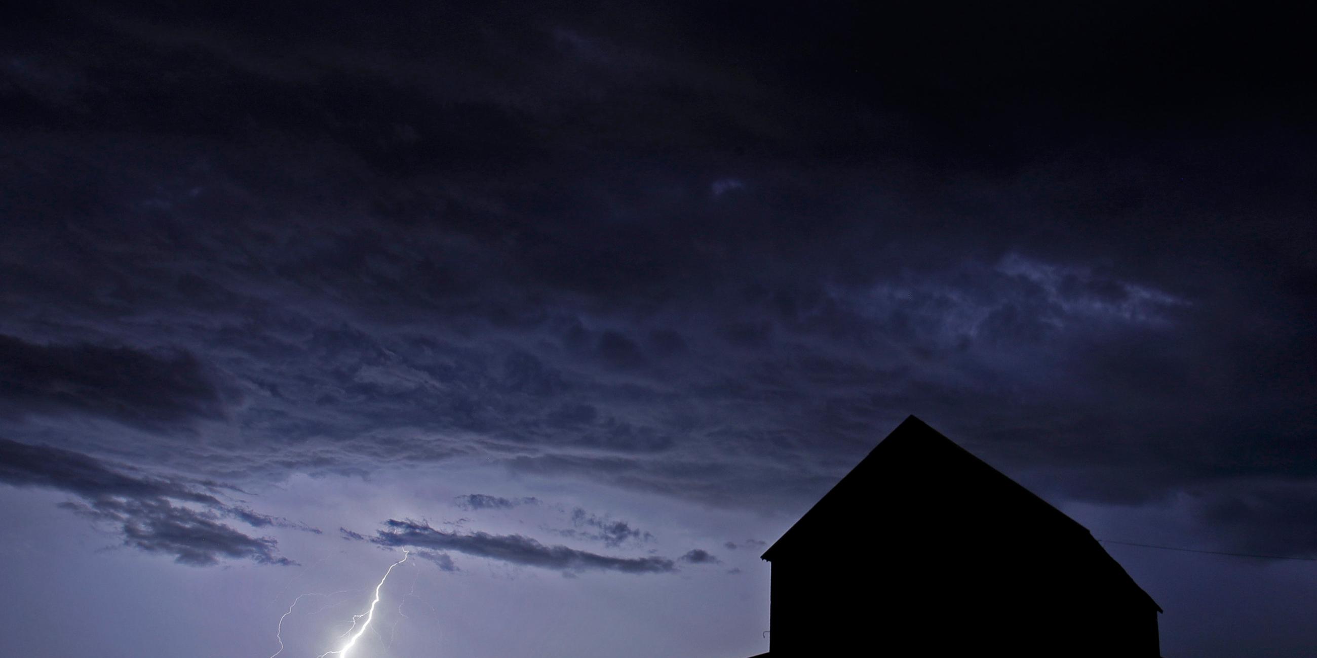 Blitzeinschlag erhellt die Silhouette eines Hauses in Kansas