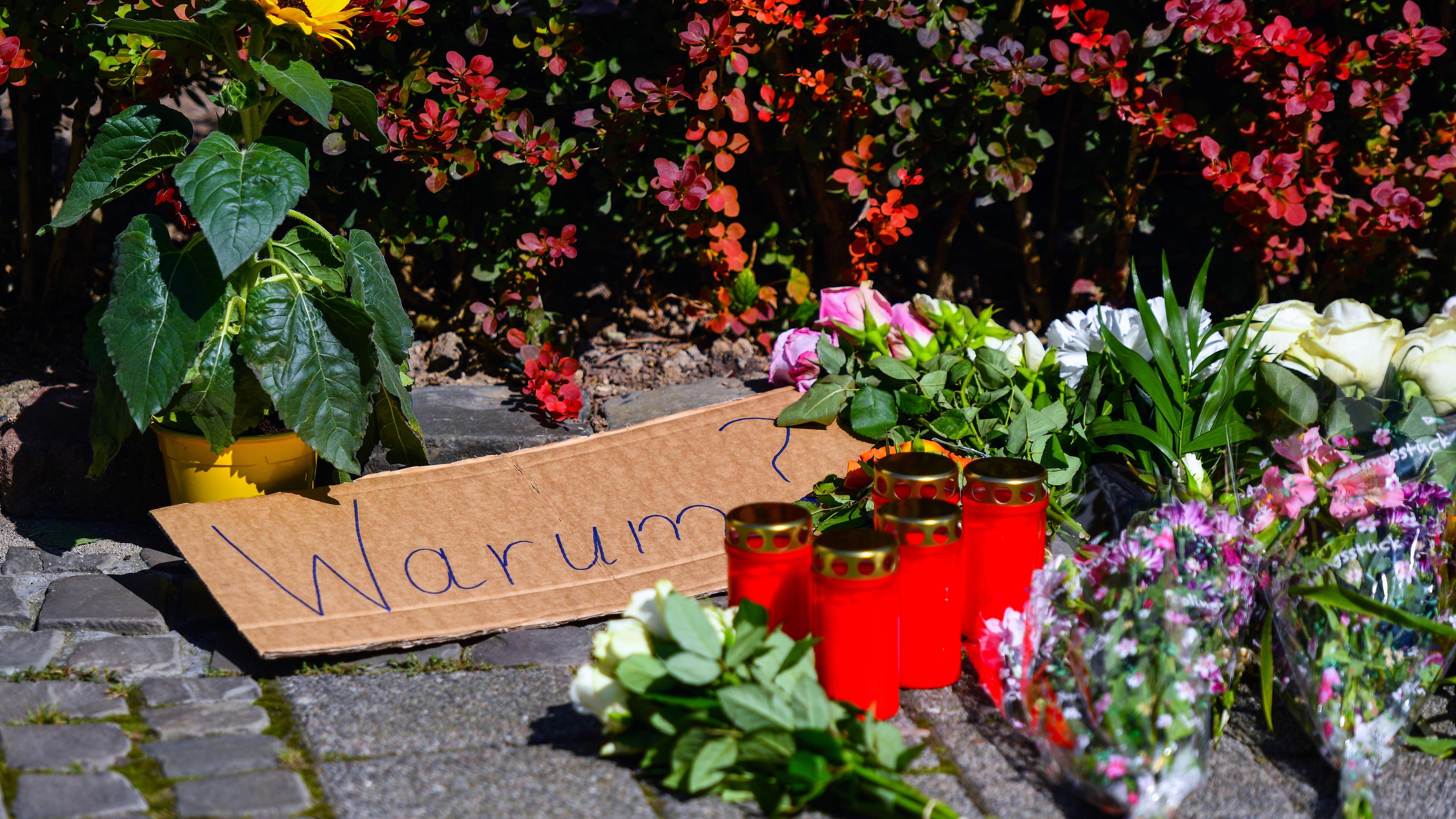 Solingen: Blumen, Kerzen und ein Pappschild mit der Aufschrift "Warum?" in der Nähe des Tatorts einer Messerattacke