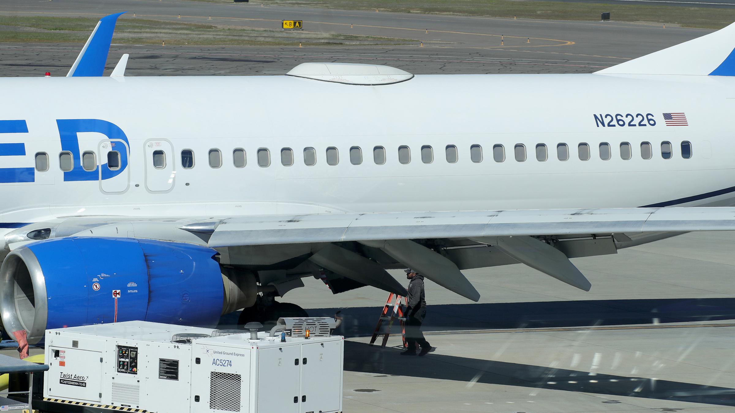 USA, Medford: Ein Mitarbeiter des Medford Jet Centers geht unter einer Boeing 737-824 von United Airlines, die auf dem Rogue Valley International-Medford Airport aus San Francisco gelandet ist.