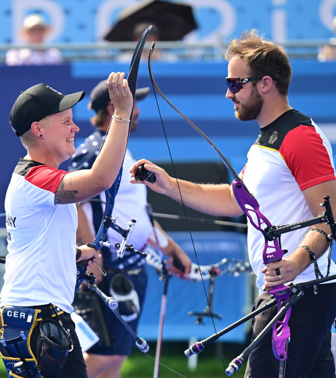 Deutschlands Bogenschützen Florian Unruh und Michelle Kroppen jubeln nach dem Sieg im Halbfinale.