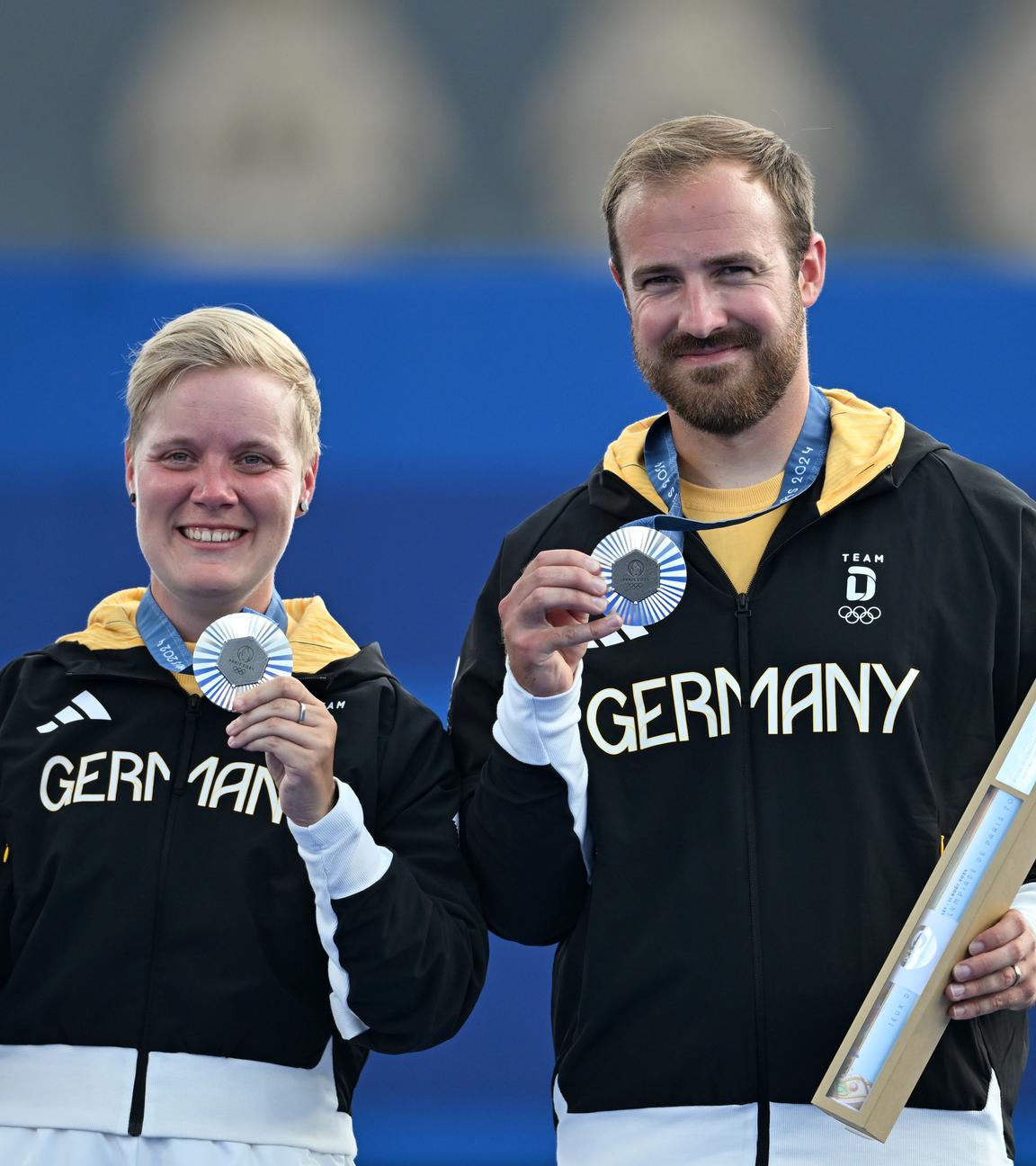 Deutschlands Florian Unruh und Michelle Kroppen jubeln über Silber bei der Siegerehrung für das mixed Bogenschießen.
