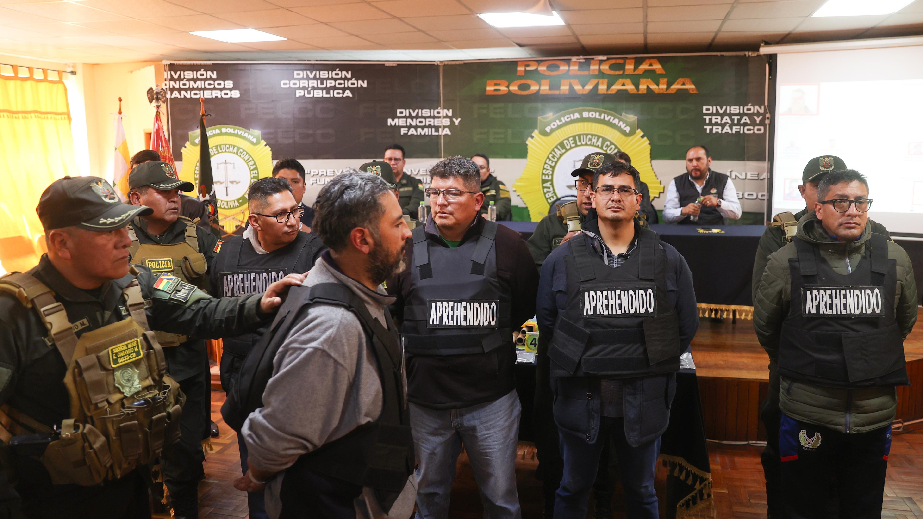 A member of the Bolivian Police escorts members of the military arrested after the coup attempt during a press conference in La Paz, Bolivia, 27 June 2024.