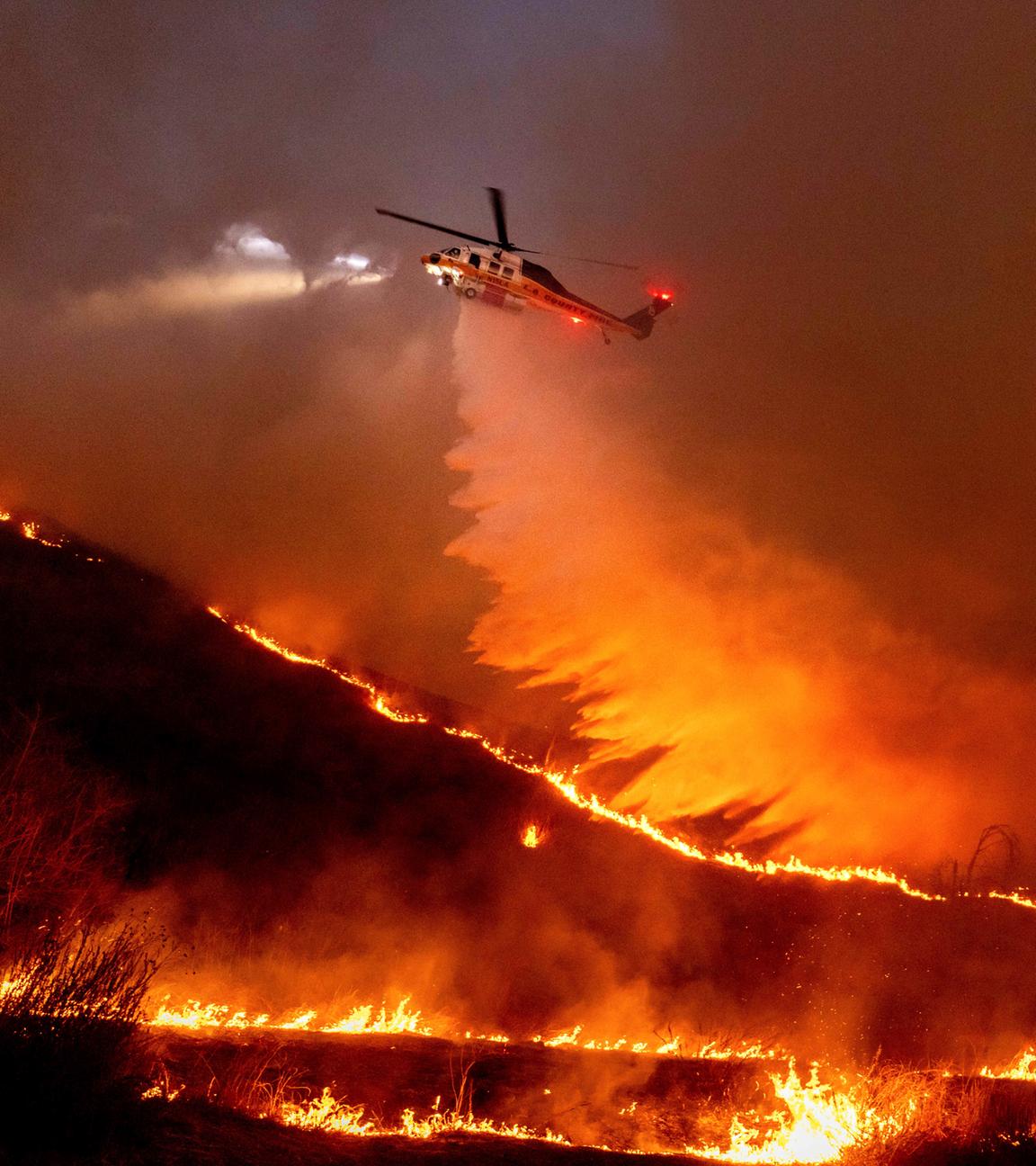 USA, Los Angeles: Ein Hubschrauber wirft Wasser auf das Kenneth-Feuer in den West Hills von Los Angeles. Archivbild