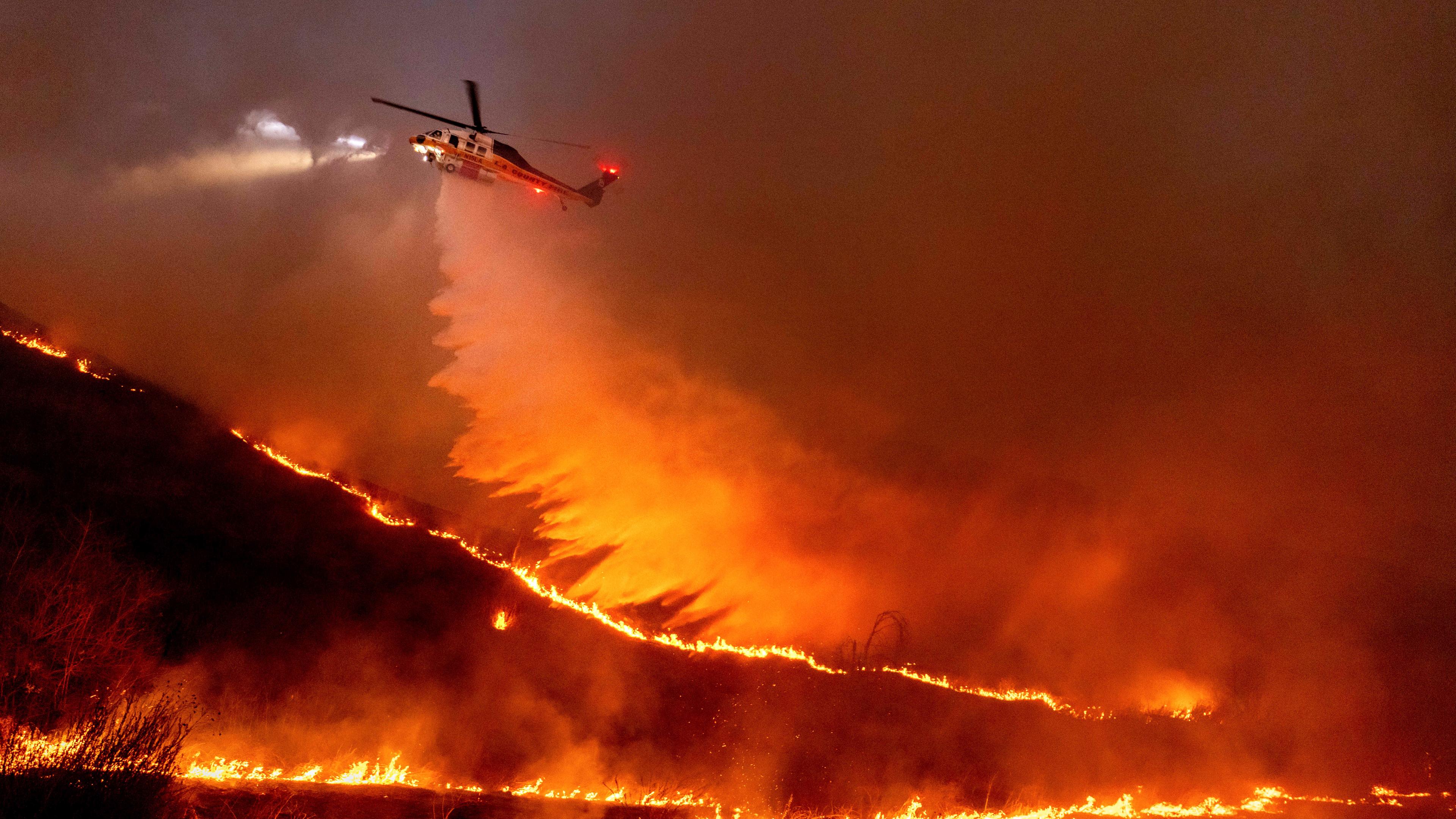 USA, Los Angeles: Ein Hubschrauber wirft Wasser auf das Kenneth-Feuer in den West Hills von Los Angeles. Archivbild