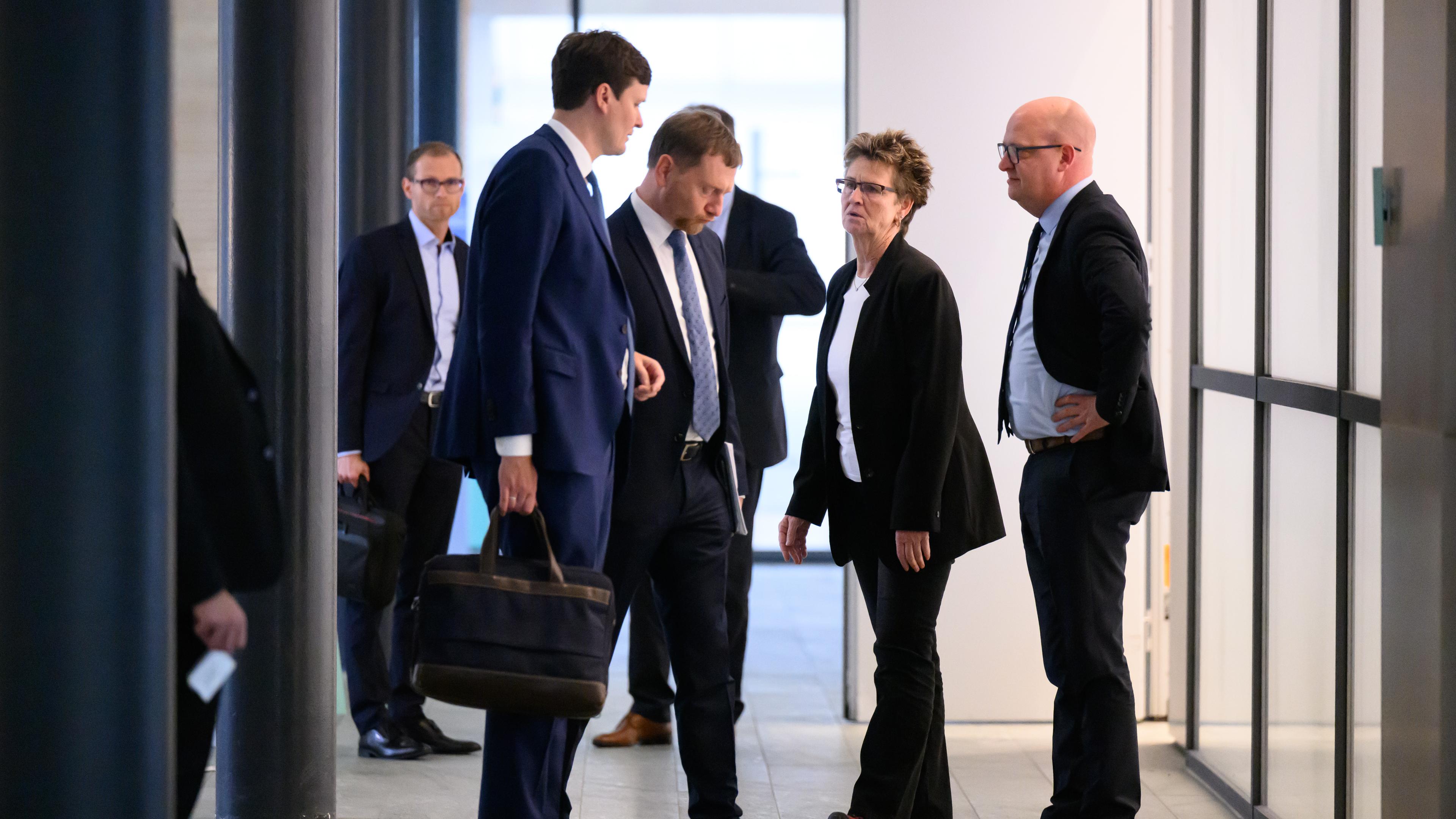 Conrad Clemens (CDU, l-r), Chef der Staatskanzlei, Michael Kretschmer (CDU), Ministerpräsident von Sachsen, Sabine Zimmermann, Co-Vorsitzende des BSW Sachsen, und Henning Homann, Co-Vorsitzender der SPD in Sachsen, sprechen nach der ersten Runde der Sondierungsgespräche zwischen CDU, BSW und SPD zur Bildung einer Landesregierung in Sachsen im Landtag auf dem Flur.