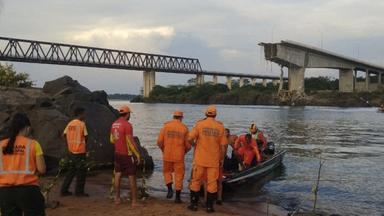 Rettungskräfte stehen am Flussufer des Rio Tocantins in Brasilien, im Hintergrund sieht man die eingestürzte Brücke.