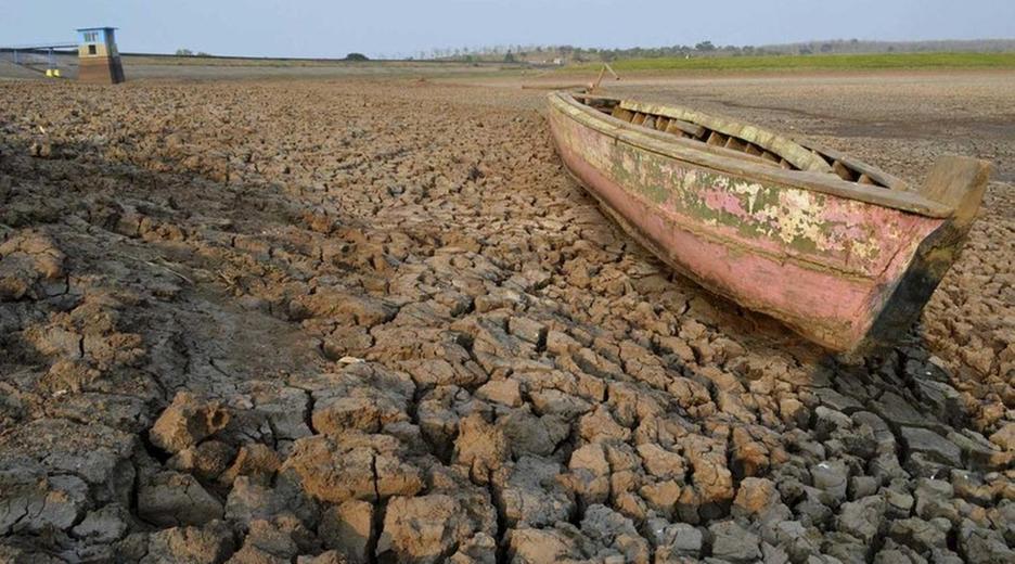 Ein Boot voller Schlamm liegt auf matschigem Untergrund. Die Erde ist aufgerissen.