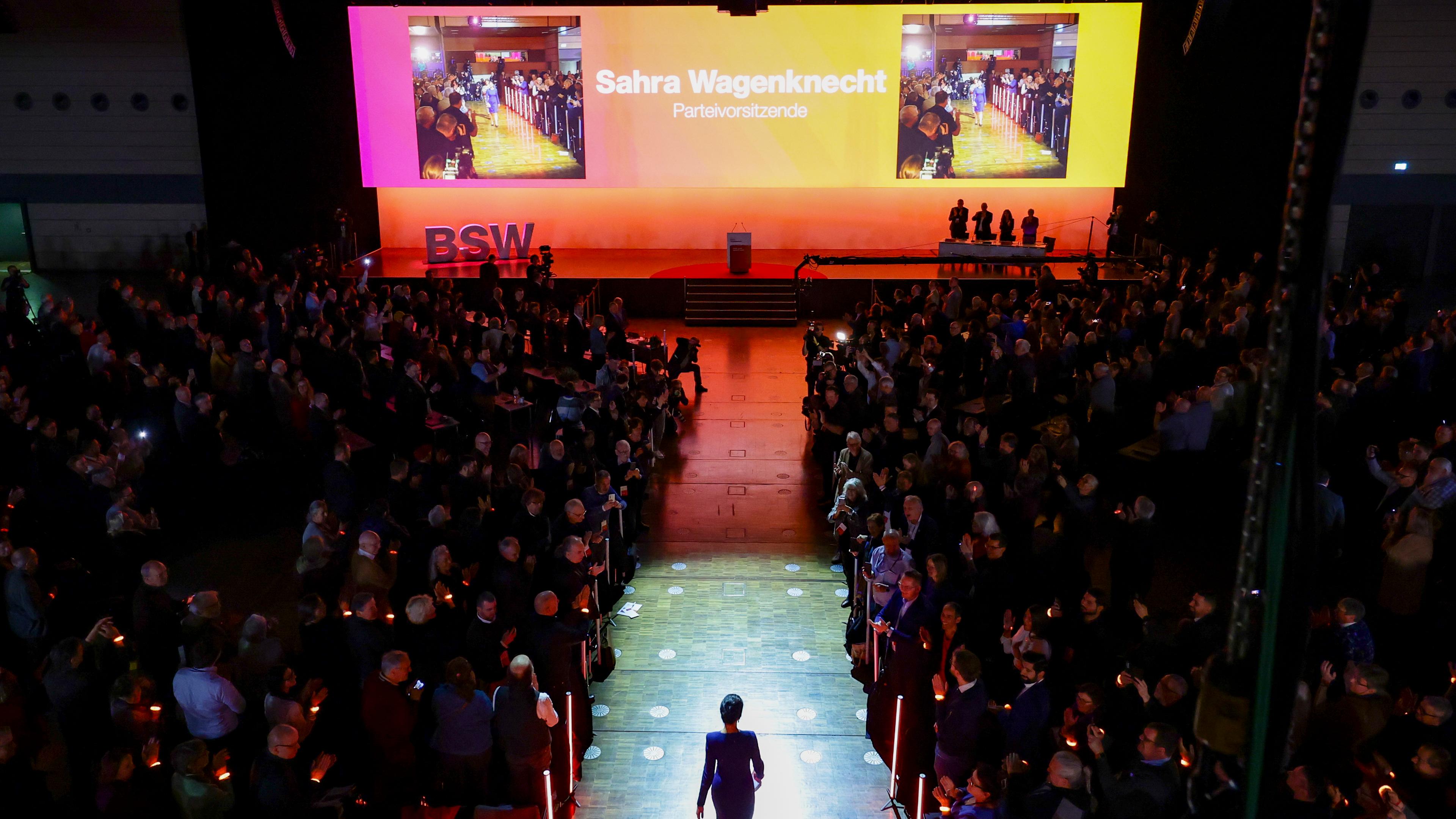 Mitglieder des BSW bei Parteitag in Bonn, Sahra Wagenknecht läuft auf die Bühne zu