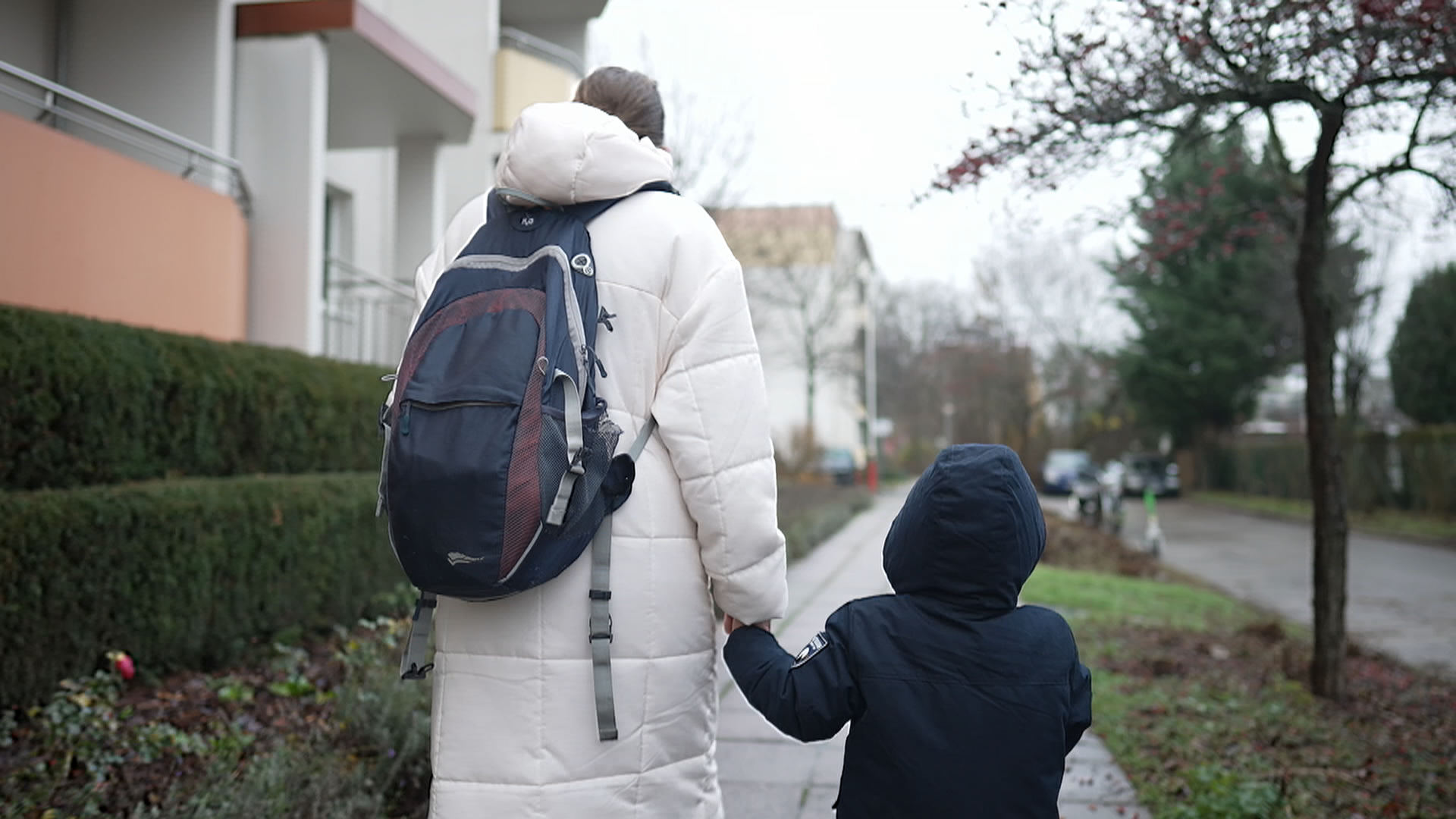 Mutter mit Kind an der Hand (Rückansicht)