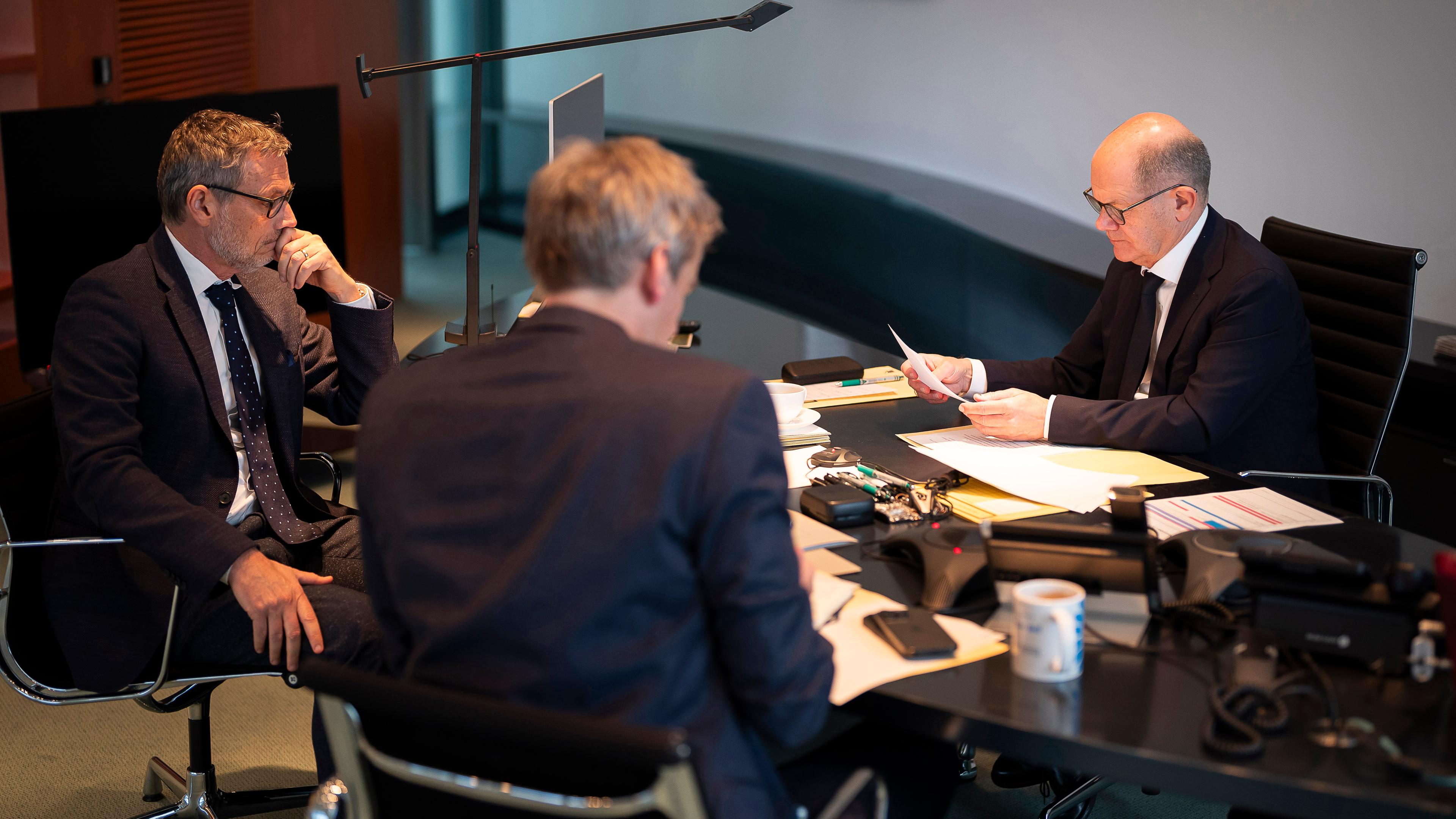 Olaf Scholz (r, SPD) in seinem Büro im Bundeskanzleramt bei einem Telefonat mit Russlands Präsident Wladimir Putin. 