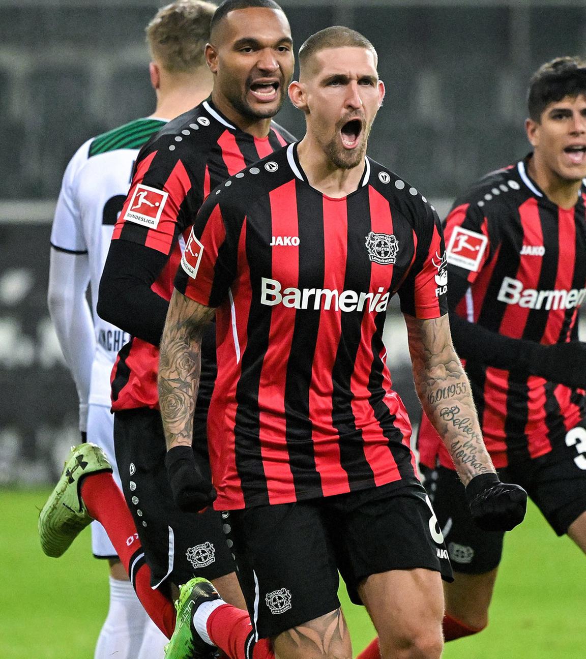 Leverkusens Robert Andrich (2-R) feiert, nachdem er beim Bundesliga-Fußballspiel zwischen Borussia Mönchengladbach und Bayer Leverkusen in Mönchengladbach mit 1:0 in Führung gegangen ist.