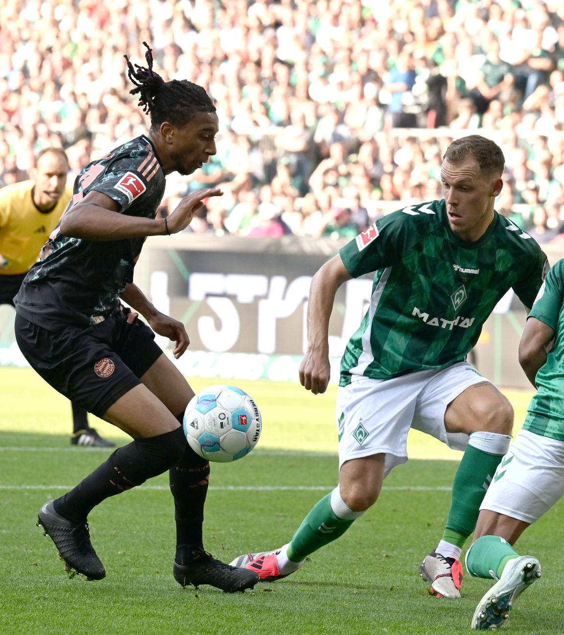 Bayerns Michael Olise passt gegen Werders Felix Agu und Senne Lynen in die Mitte zum 0:2.