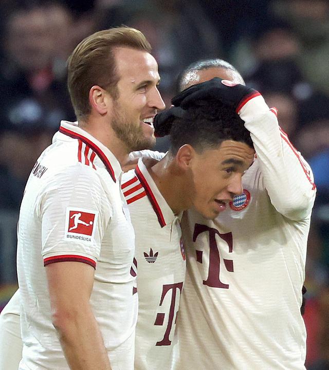 Torschütze Jamal Musiala vom FC Bayern München feiert mit Harry Kane und Leroy Sané das 1:0 gegen den 1. St Pauli.