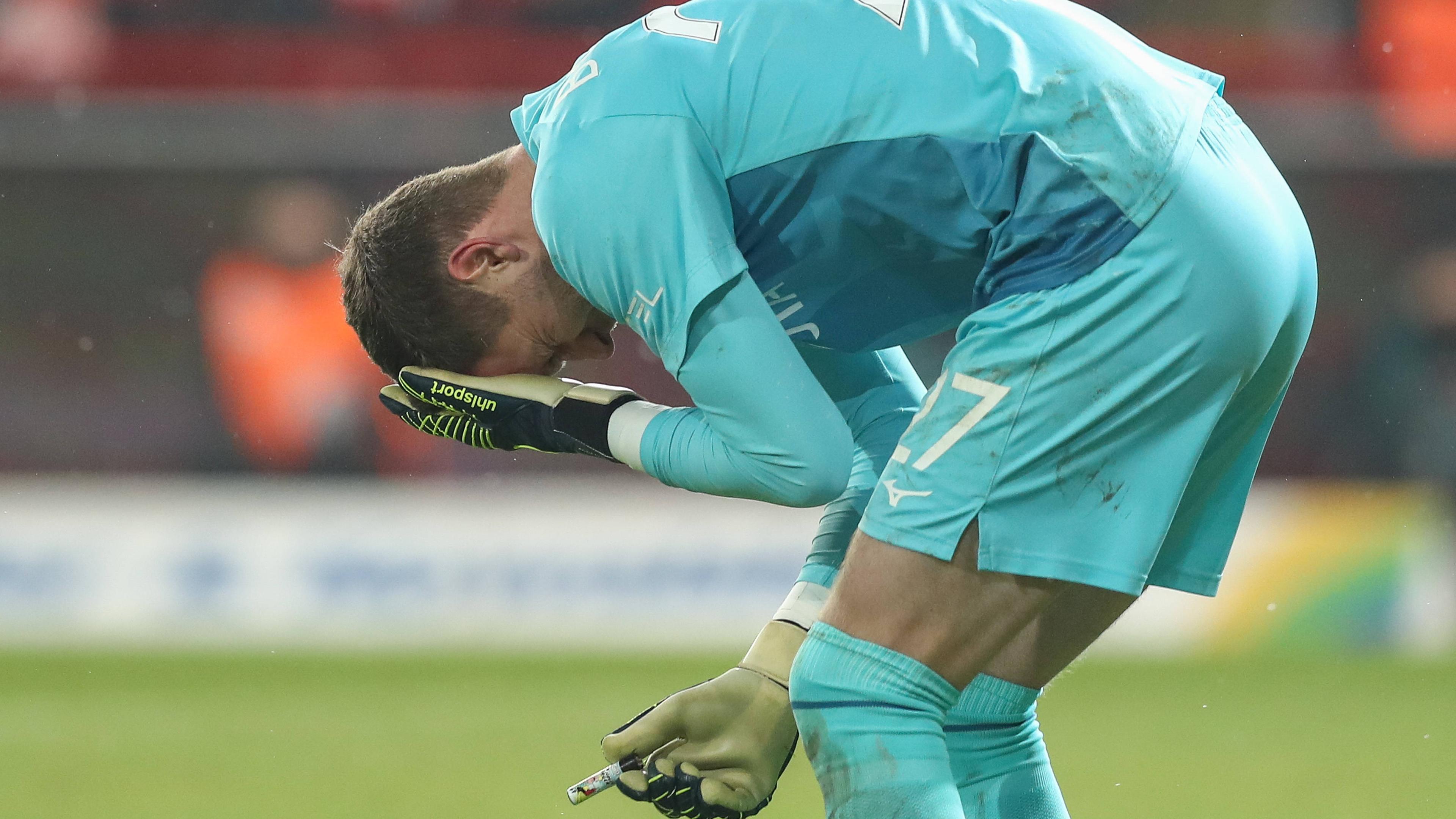 Bochums Torwart Patrick Drewes hält sich die Hand an den Kopf nachdem er mit einem Feuerzeug beworfen wurde beim Spiel gegen Union Berlin.