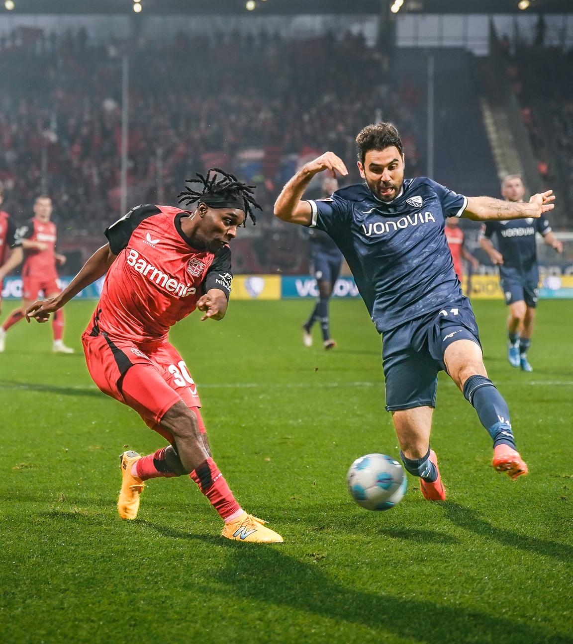 Jeremie Frimpong von Bayer Leverkusen und Bochums Gerrit Holtmann kämpfen um den Ball.