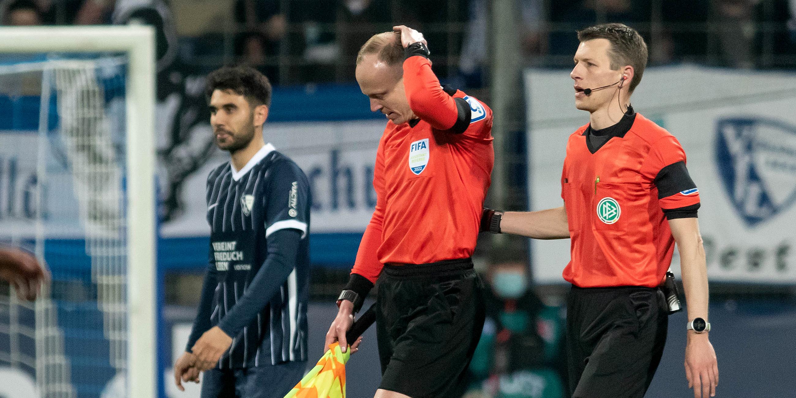 Das Schiedsrichtergespann um Benjamin Cortuns (r) verlässt während des Spiels das Spielfeld, nachdem Schiedsrichterassistent Christian Gittelmann (2.v.r.) einen Becher an den Kopf bekommen hatte.