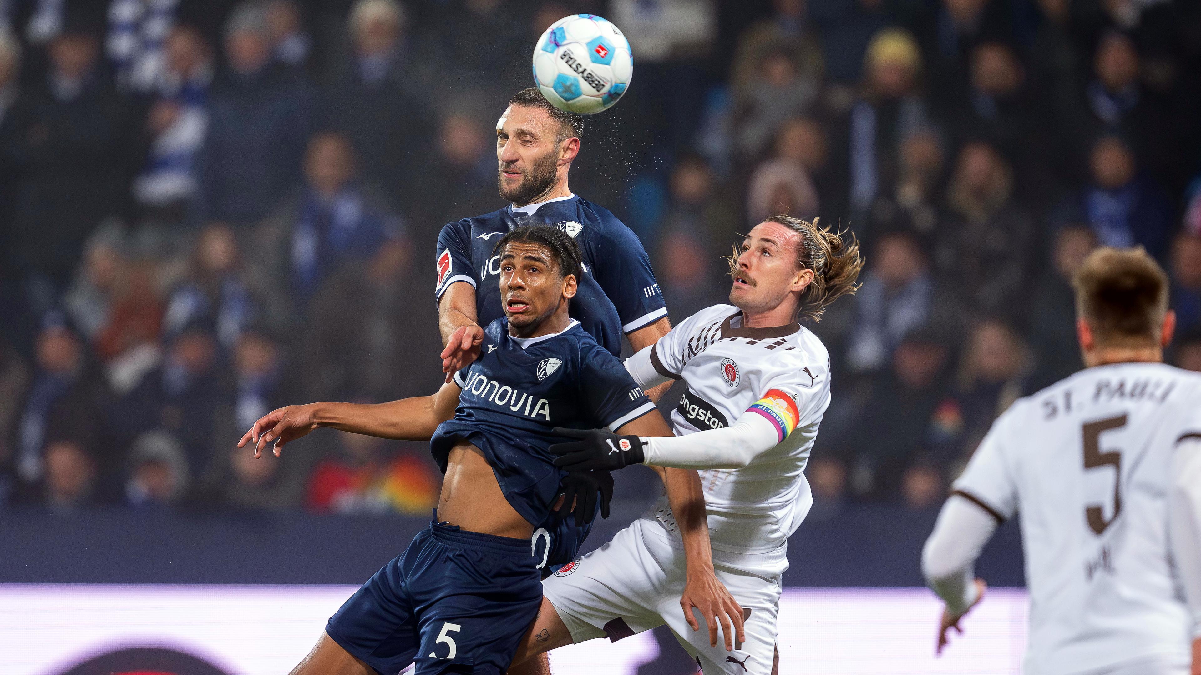 Bochums Spieler Bernardo und Ivan Ordets kämpfen mit St. Paulis Jackson Irvine um den Ball.