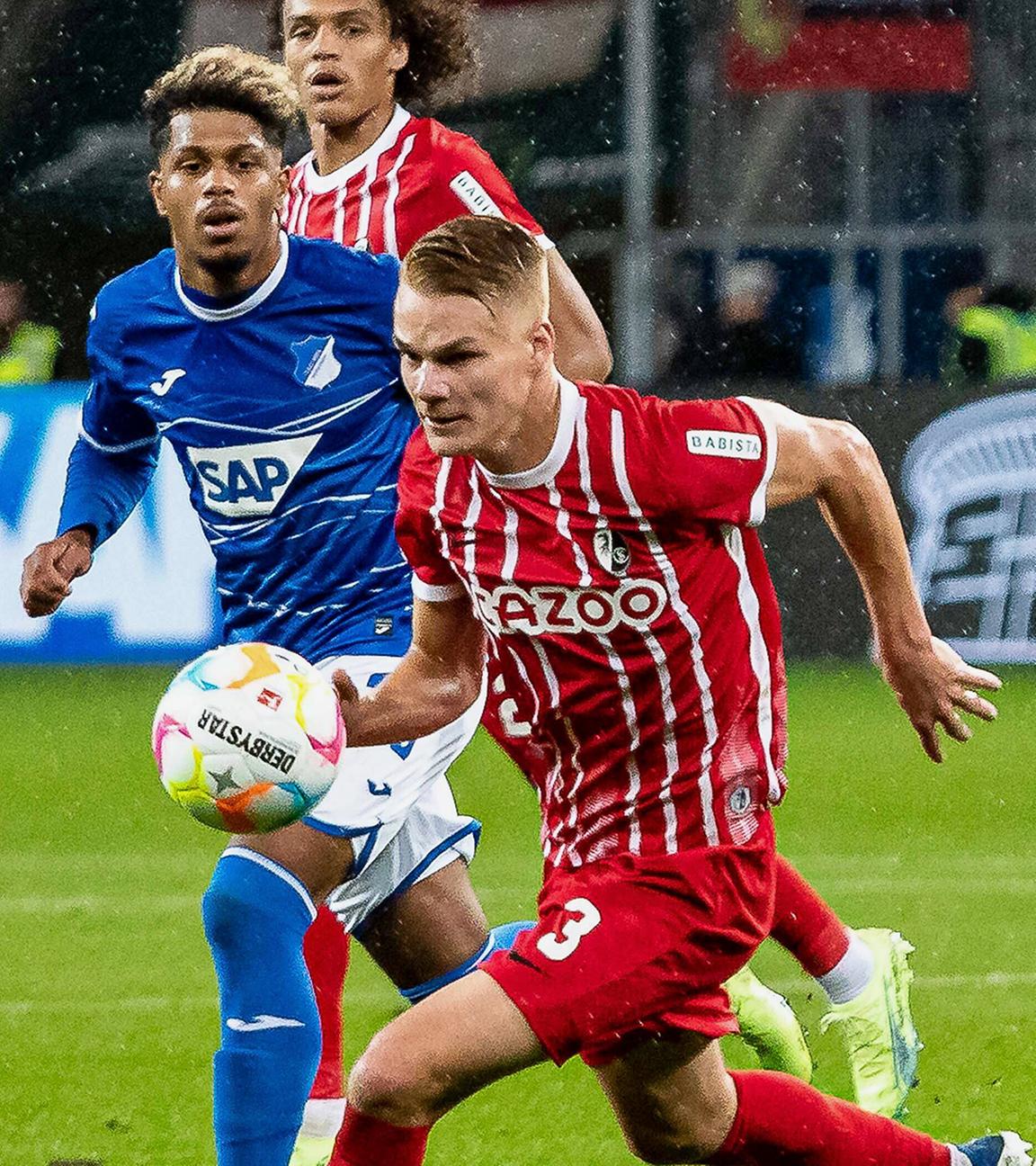 Philipp Lienhart vom SC Freiburg und Hoffenheims Angelino kämpfen um den Ball am 18.09.2022 in Sinsheim.