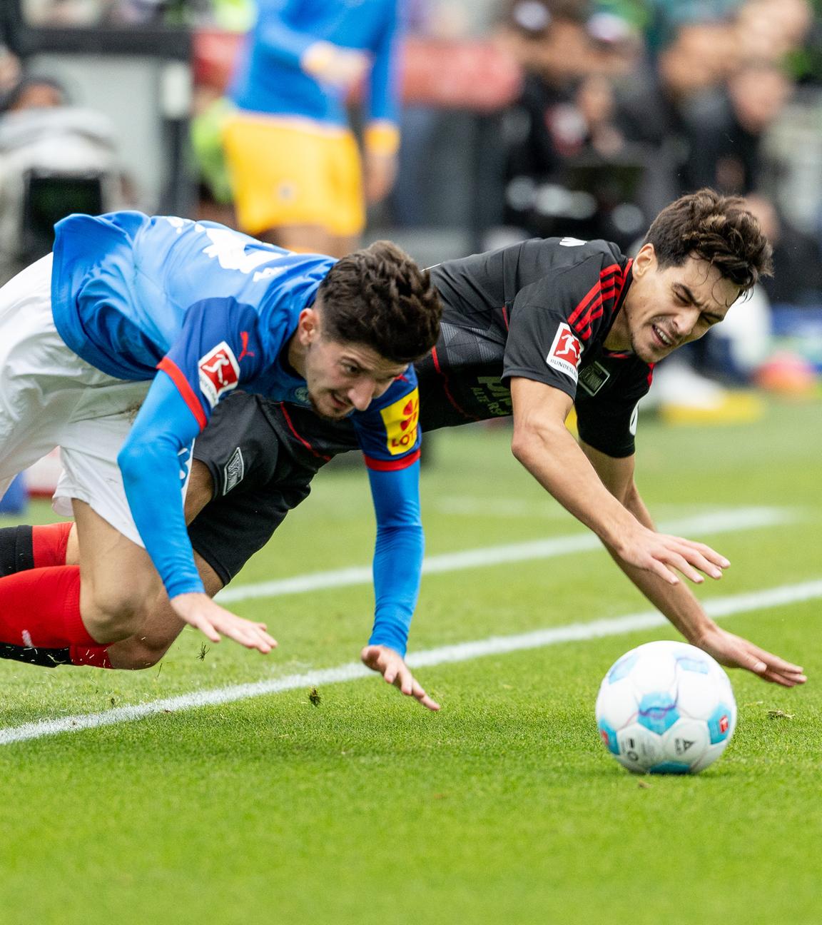 Kiels Armin Gigovic und Berlins Diogo Leite kämpfen um den Ball und fallen dabei auf den Boden.