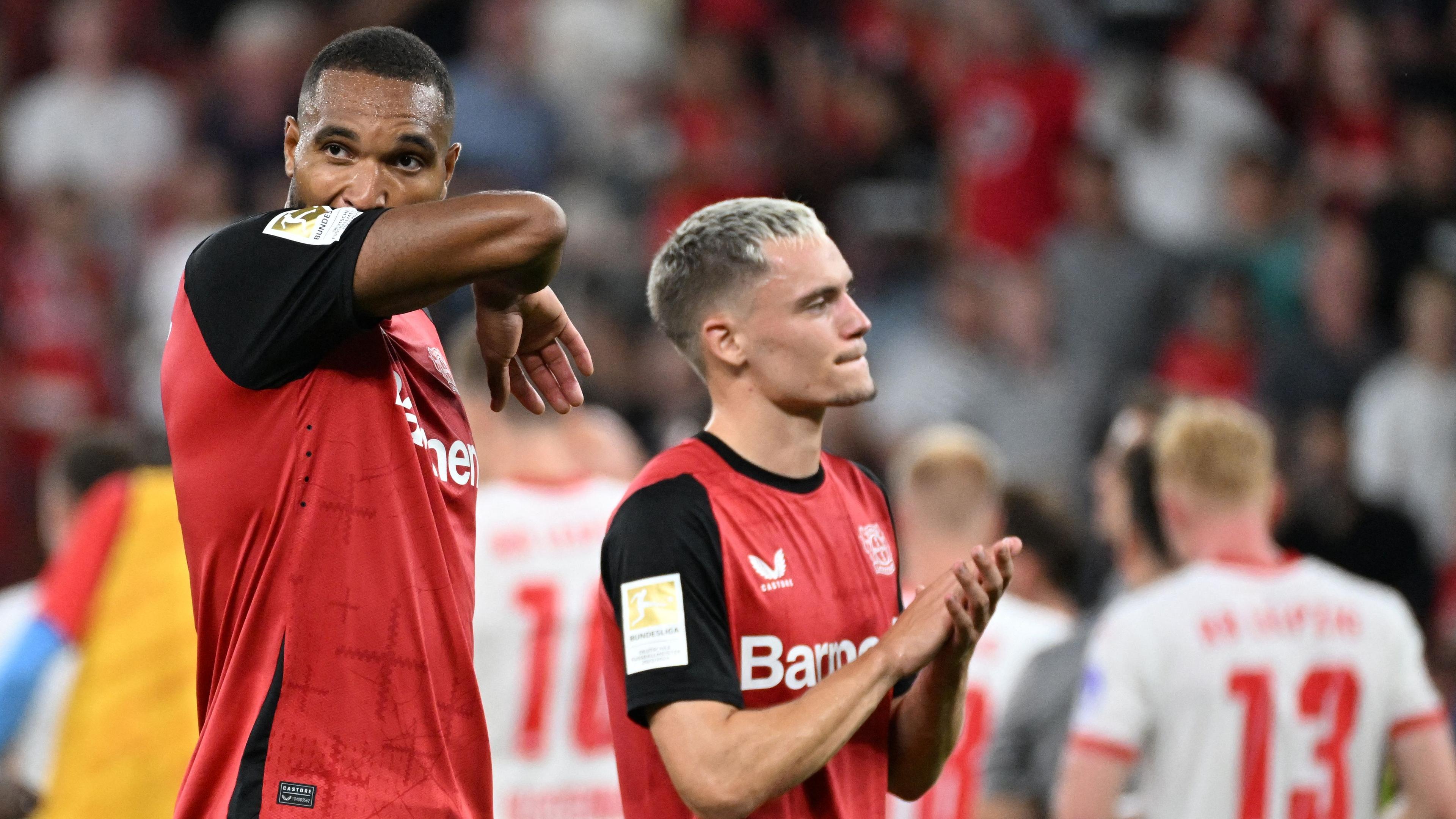 Bayer Leverkusens Verteidiger (Nr. 04) Jonathan Tah und Bayer Leverkusens  Mittelfeldspieler (Nr. 10) Florian Wirtz reagieren nach dem Bundesligaspiel