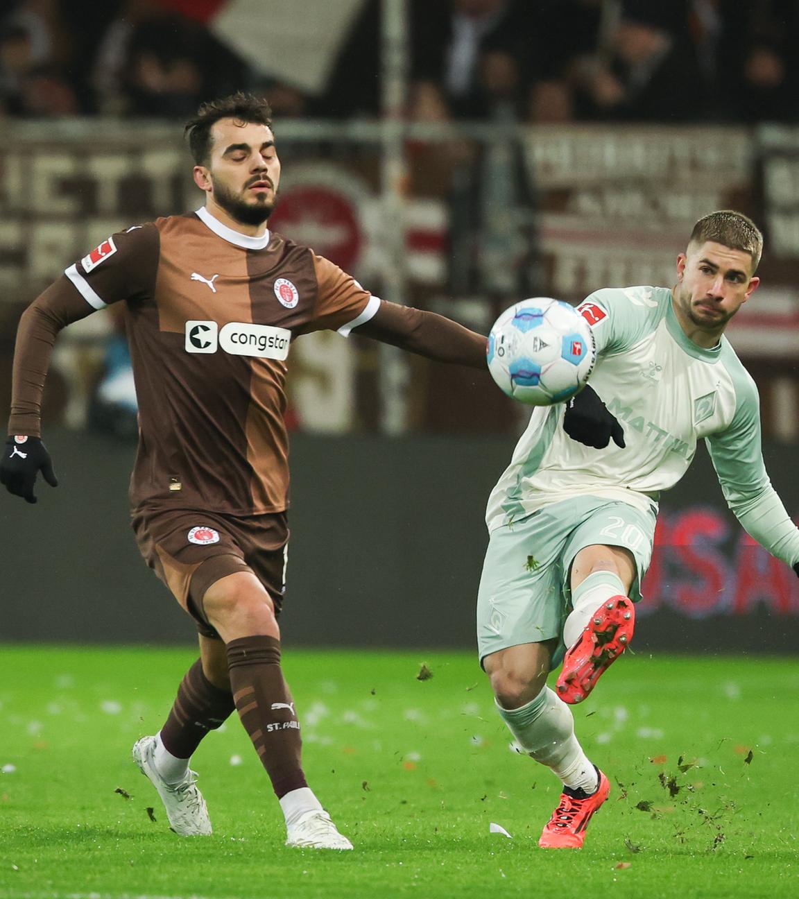 St. Paulis Daniel Sinani und Bremens Romano Schmid im Kampf um den Ball.