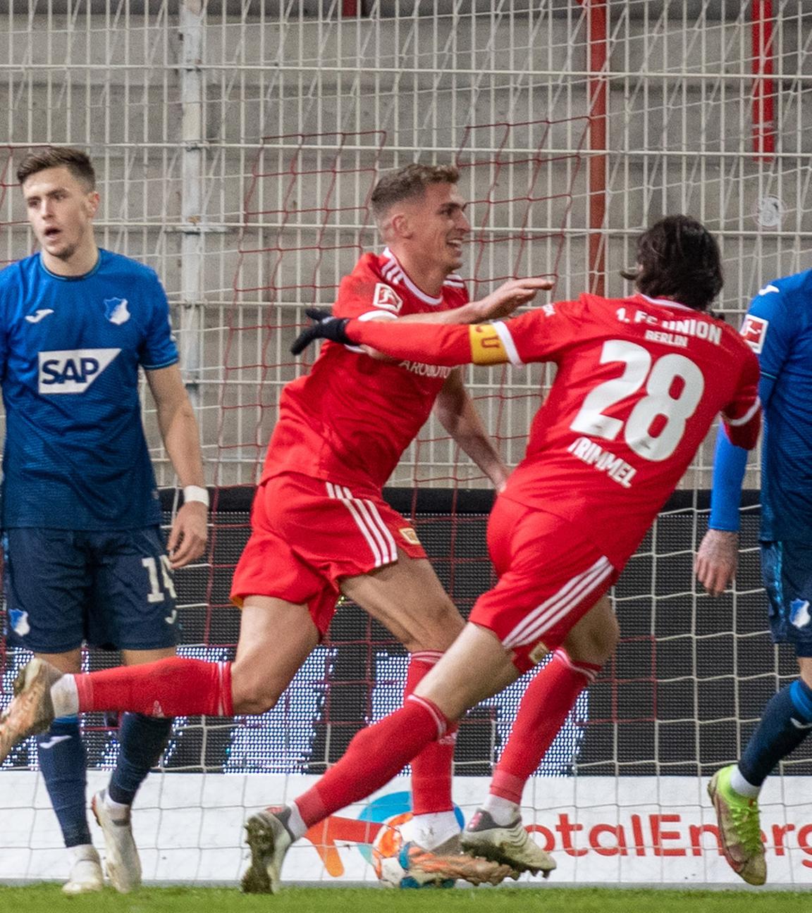 15.01.2022, Berlin, 1. FC Union Berlin gegen TSG 1899 Hoffenheim, An der Alten Försterei, erlins Grischa Prömel (M) jubelt nach seinem Treffer zum 2:1 mit seinem Teamkollegen Christopher Trimmel (2.v.r.). Torwart Oliver Baumann (l) und Christoph Baumgartner (2.v.l.) von der TSG Hoffenheim reagieren.