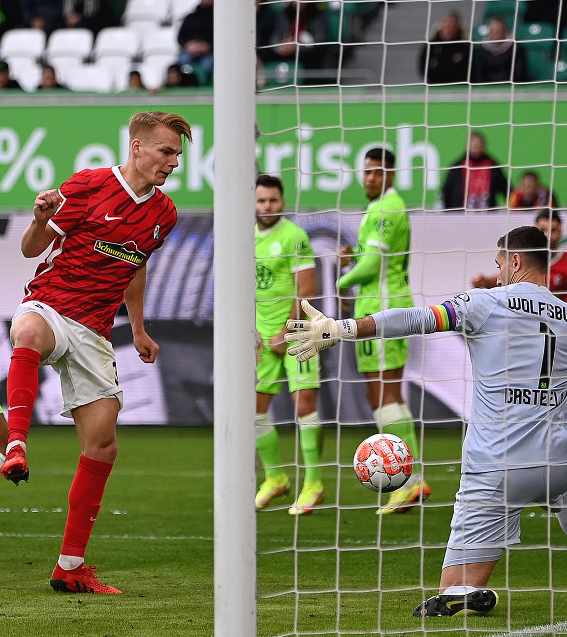 Freiburgs Philipp Lienhart (m) erzielt gegen Wolfsburgs Torwart Koen Casteels (r) ein Tor am 23.10.2021 in der Volkswagen-Arena.