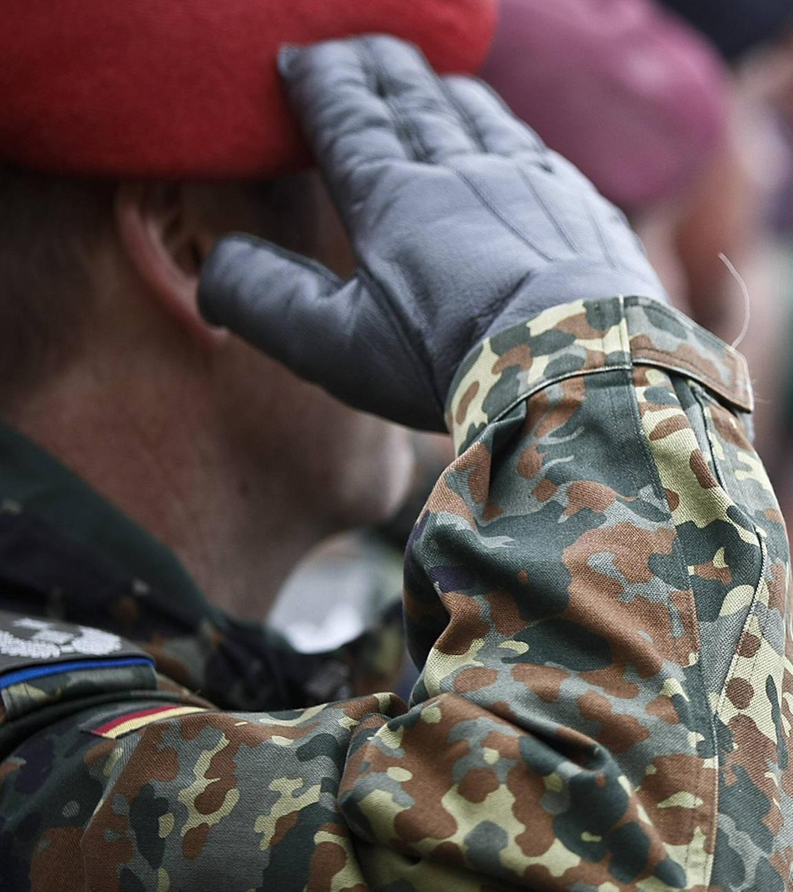 Soldat von der Seite, der die Hand zum Gruß hebt.