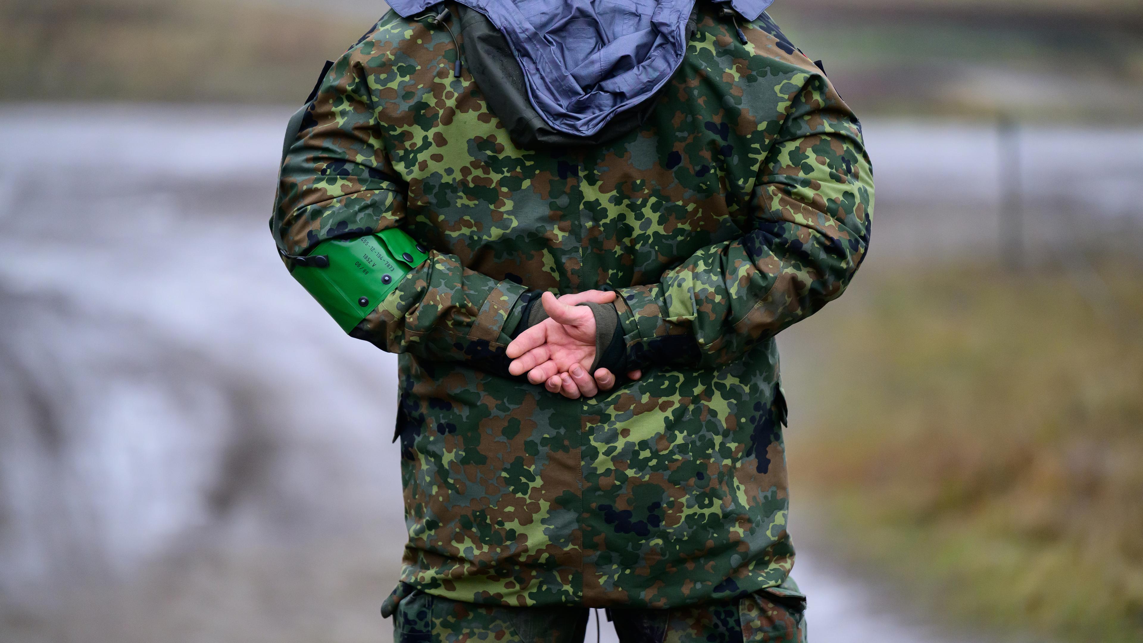 Ein Bundeswehrsoldat mit verschränkten Armen von hinten zu sehen