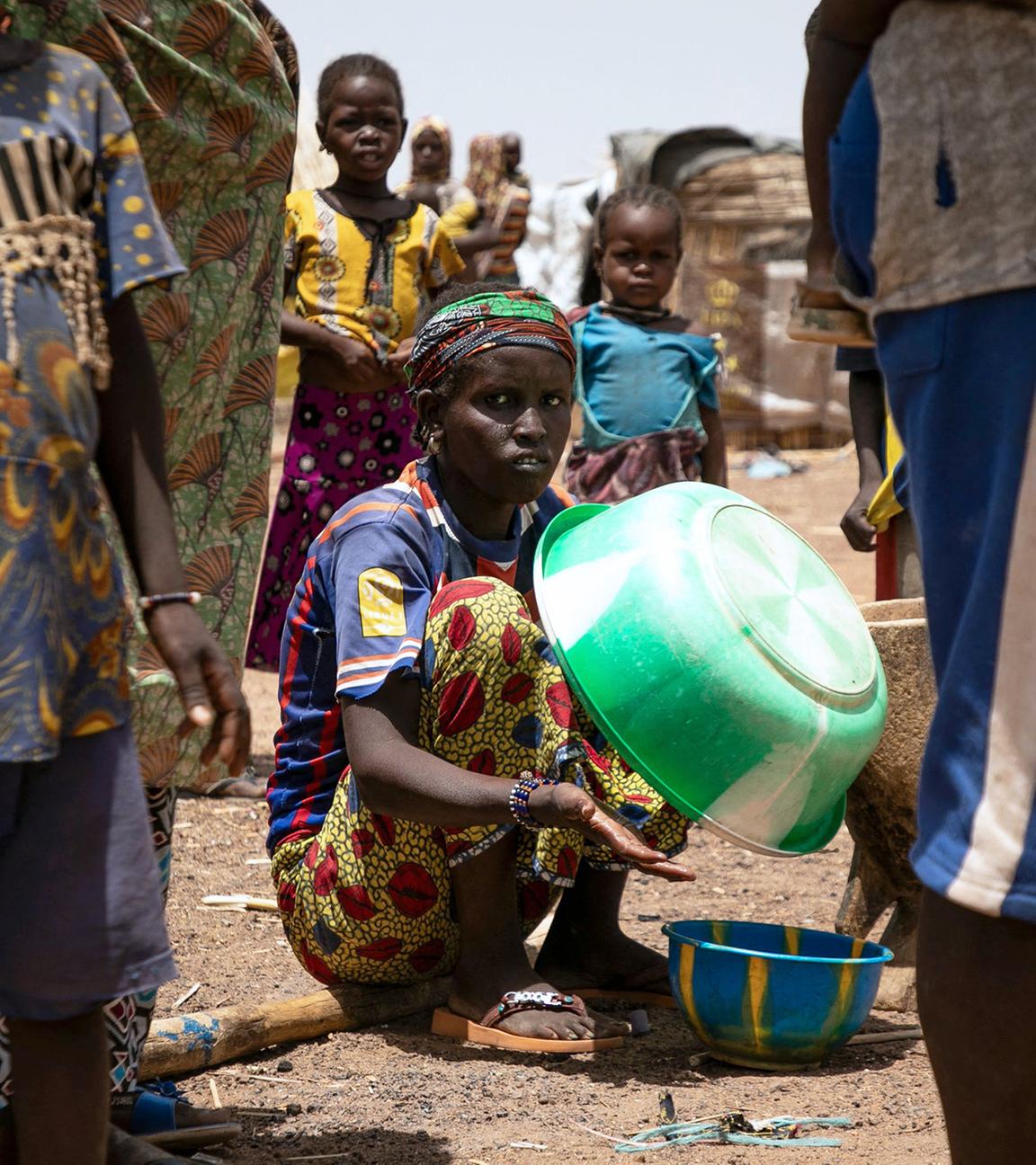 Eine vertriebene Frau hält eine Plastikschüssel im Flüchtlingslager Torodi in Dori, Burkina Faso